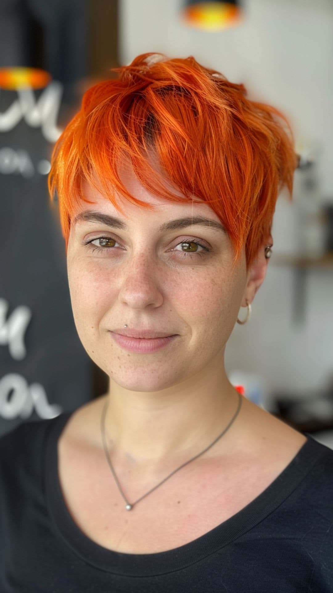 A woman modelling an orange pixie cut.