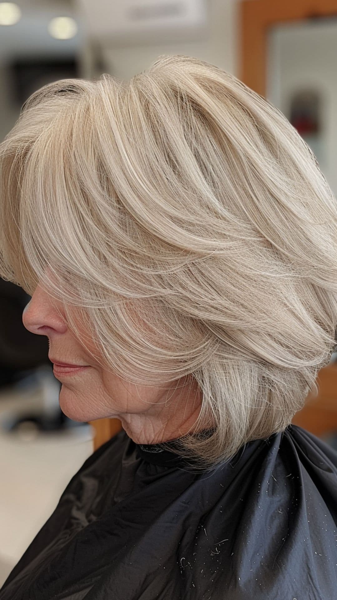 An old woman modelling a champagne blonde layered bob.