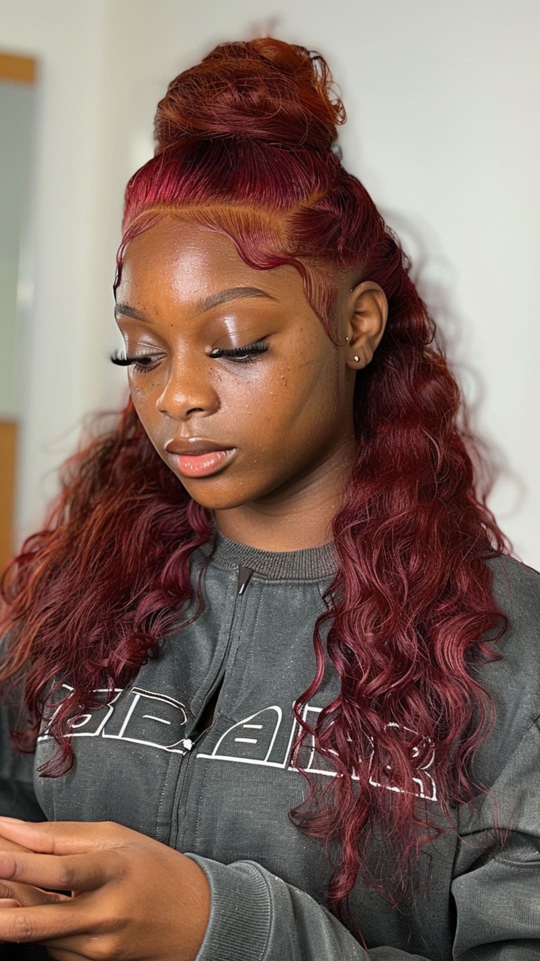 A black woman modelling a cherry red hair.