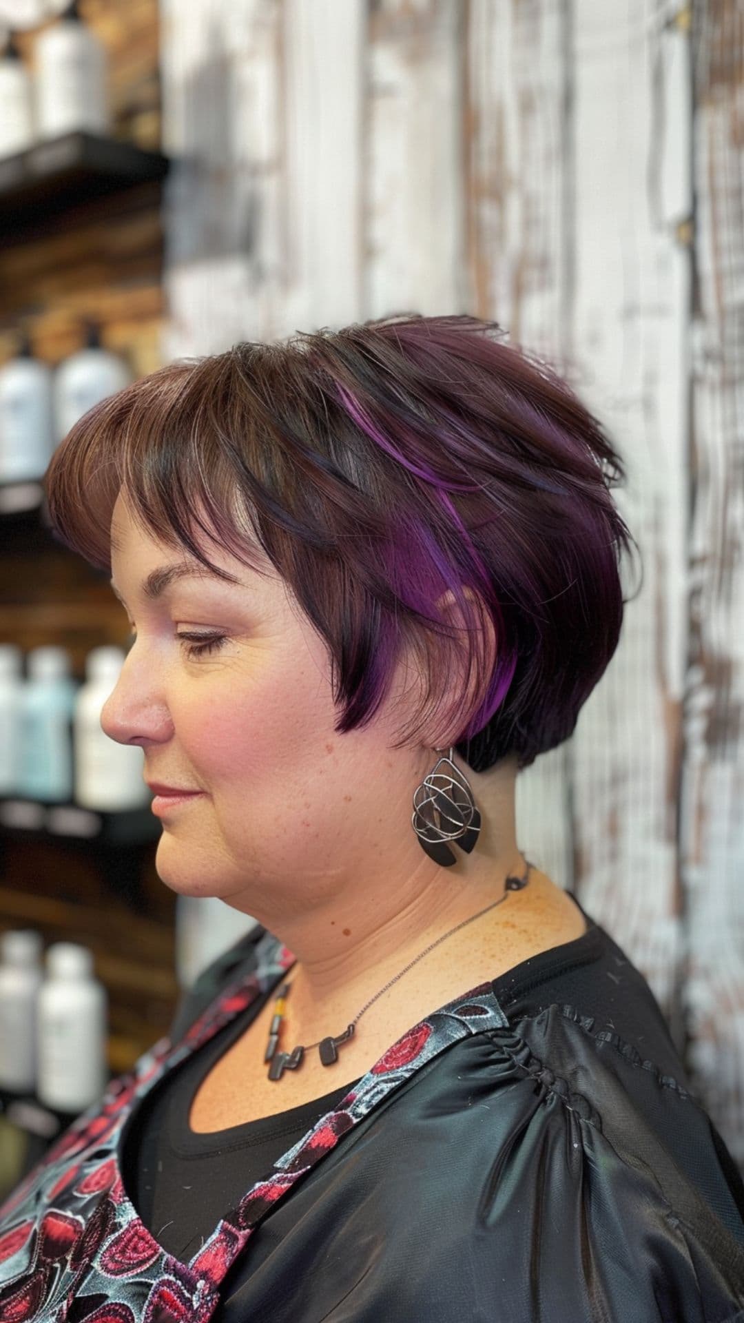 A old woman modelling a pixie bob cut with purple accents.