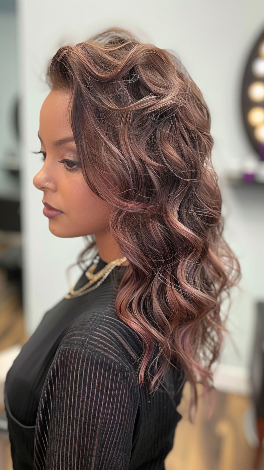 A woman modelling a black hair with rose gold highlights.