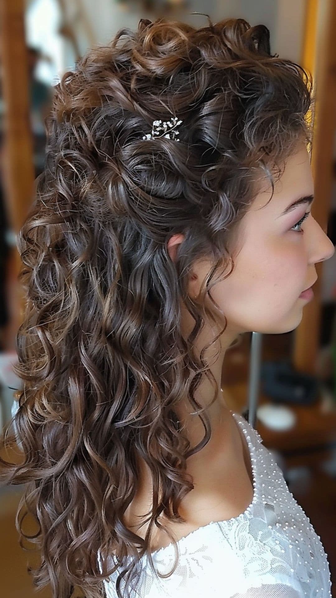 A woman modelling a curly half up half down hairstyle.