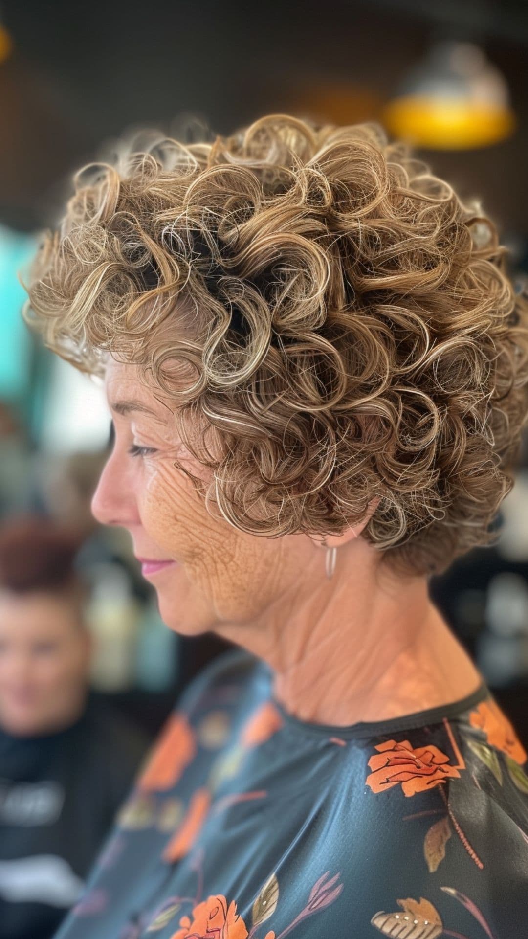 An old woman modelling a curly pixie bob.