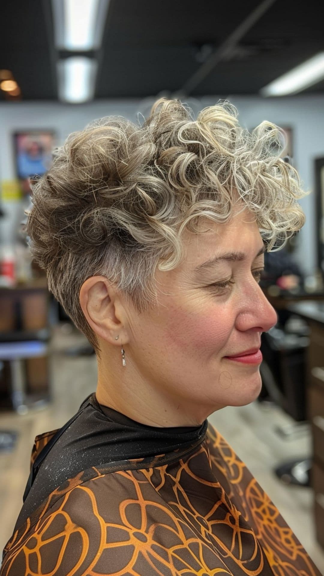 An old woman modelling a curly pixie with undercut.