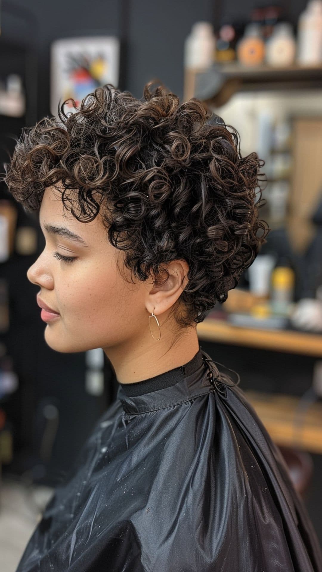 A woman modelling a curly pixie cut with volume.