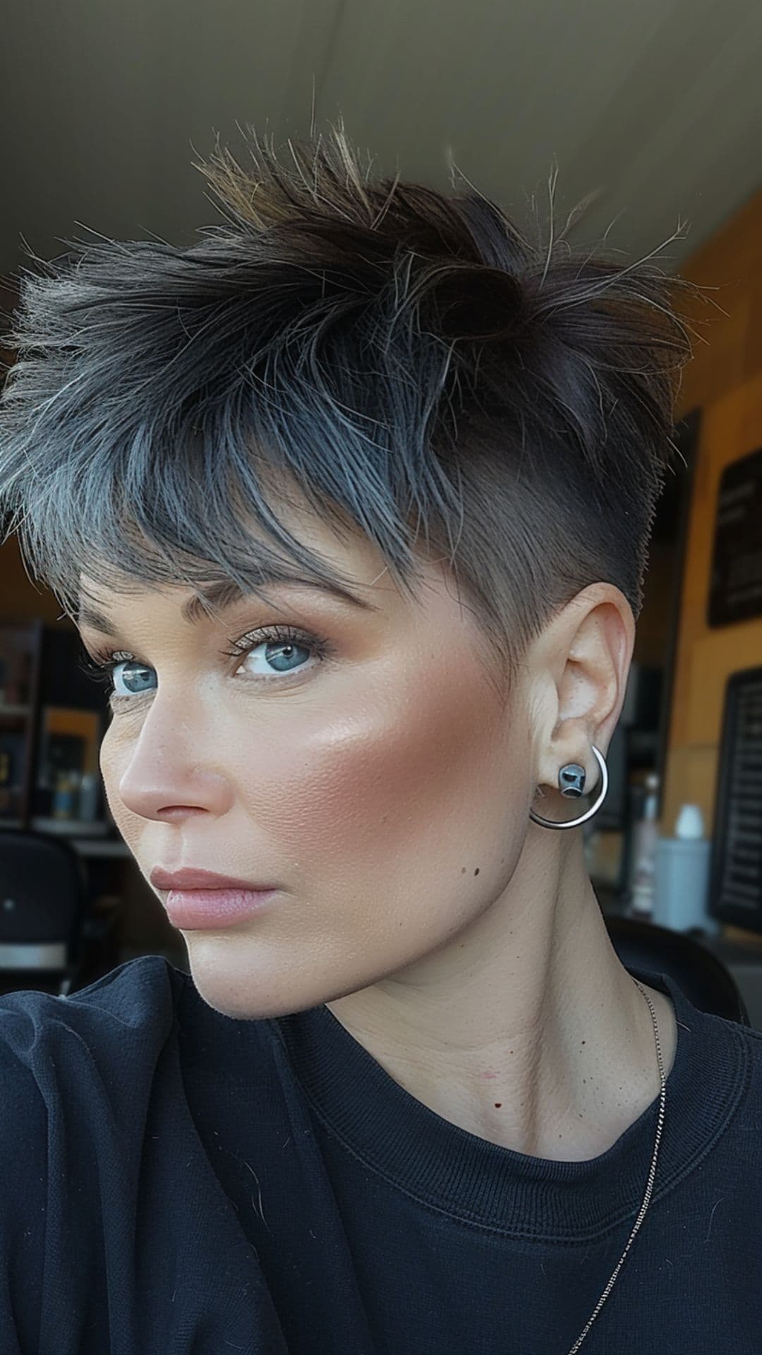 A woman modelling an edgy pixie cut with shaved sides.