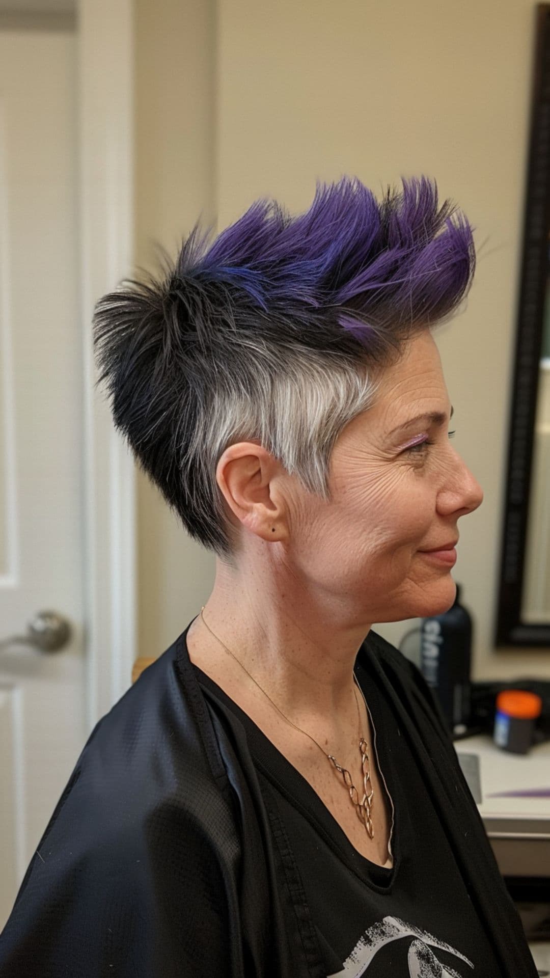 An old woman modelling a faux hawk with purple highlights.