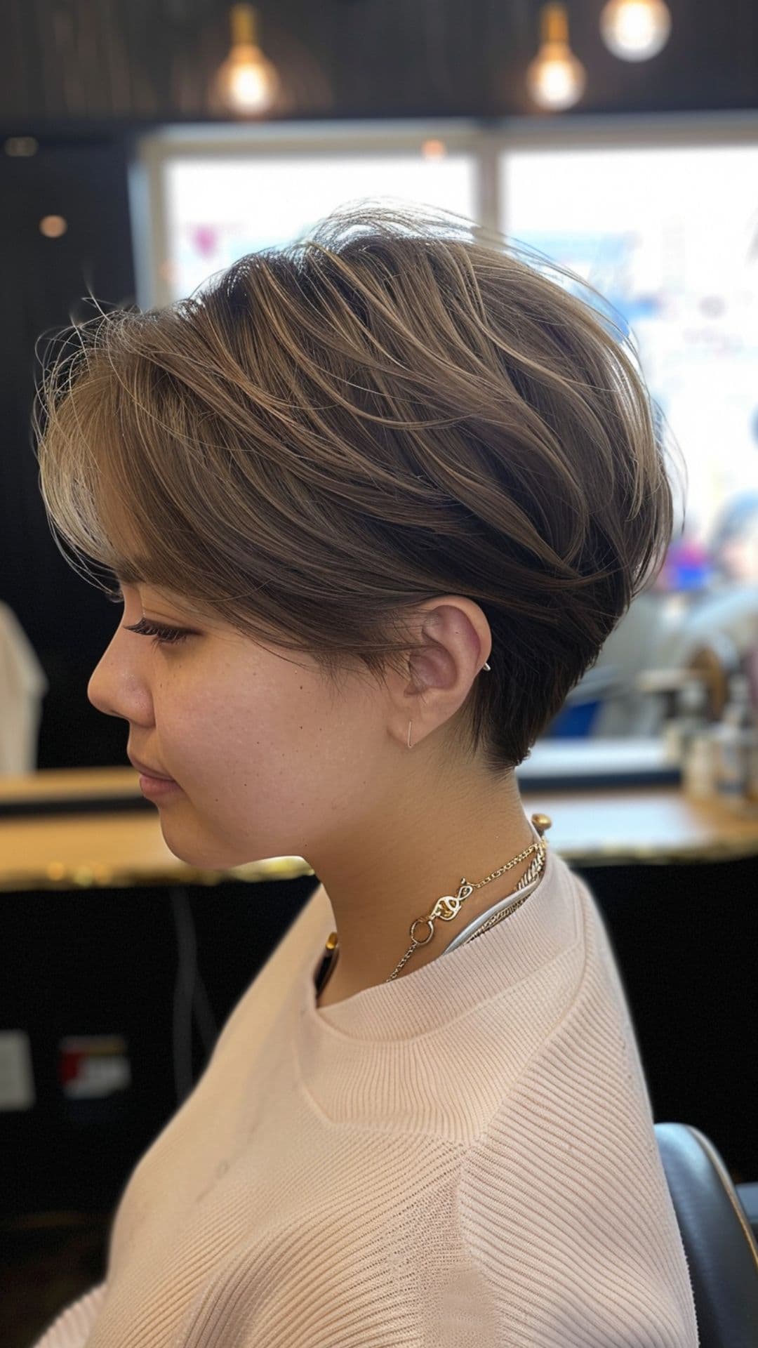 A woman modelling a graduated pixie cut with volume at the crown.