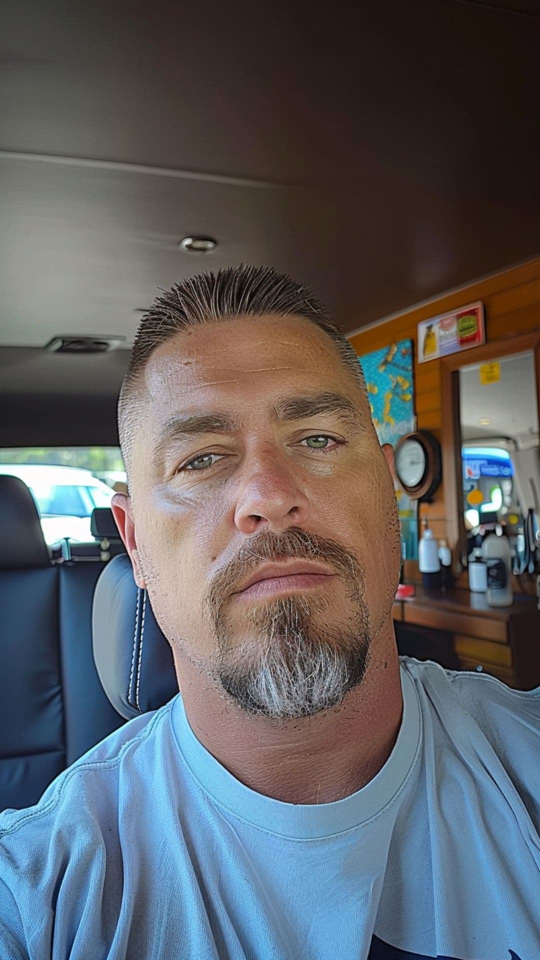 A man modelling a high and tight haircut with goatee.