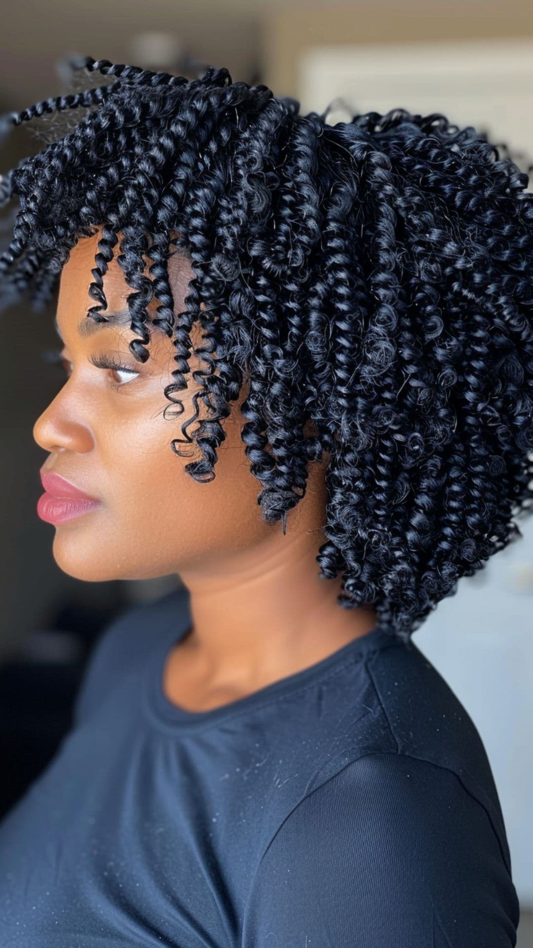 A black woman modelling a jet black curly hair.