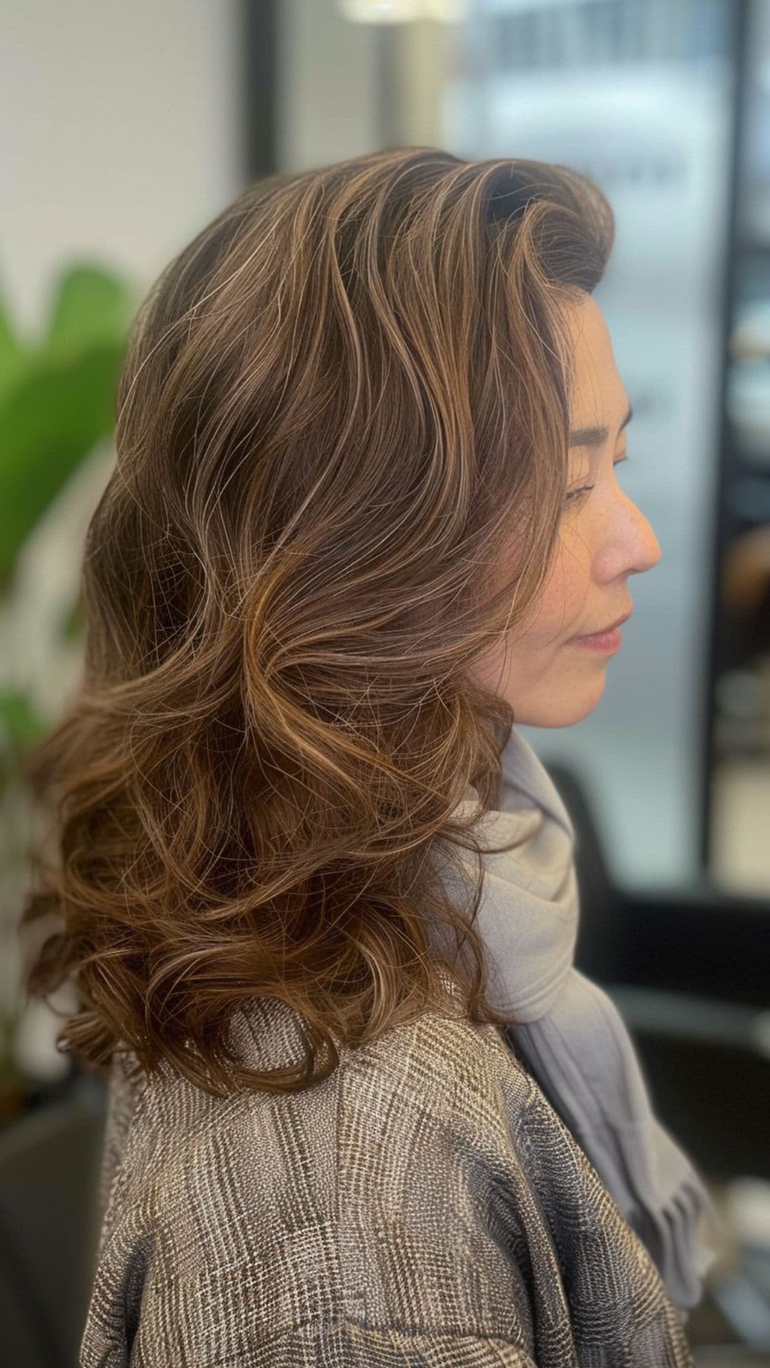 An old woman modelling a layered cut with soft waves.