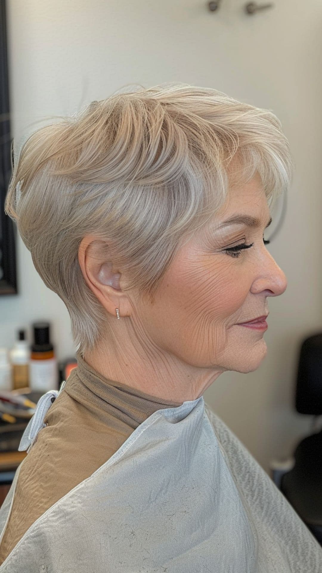 An old woman modelling a layered pixie with tapered sides.