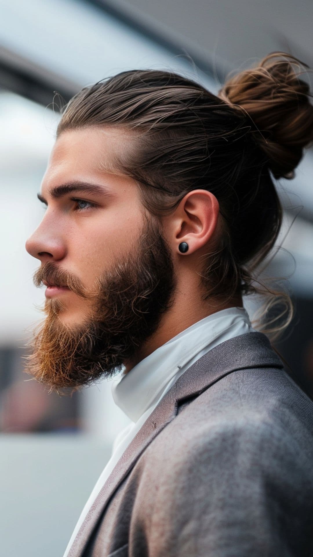 A man modelling a man bun with beard.