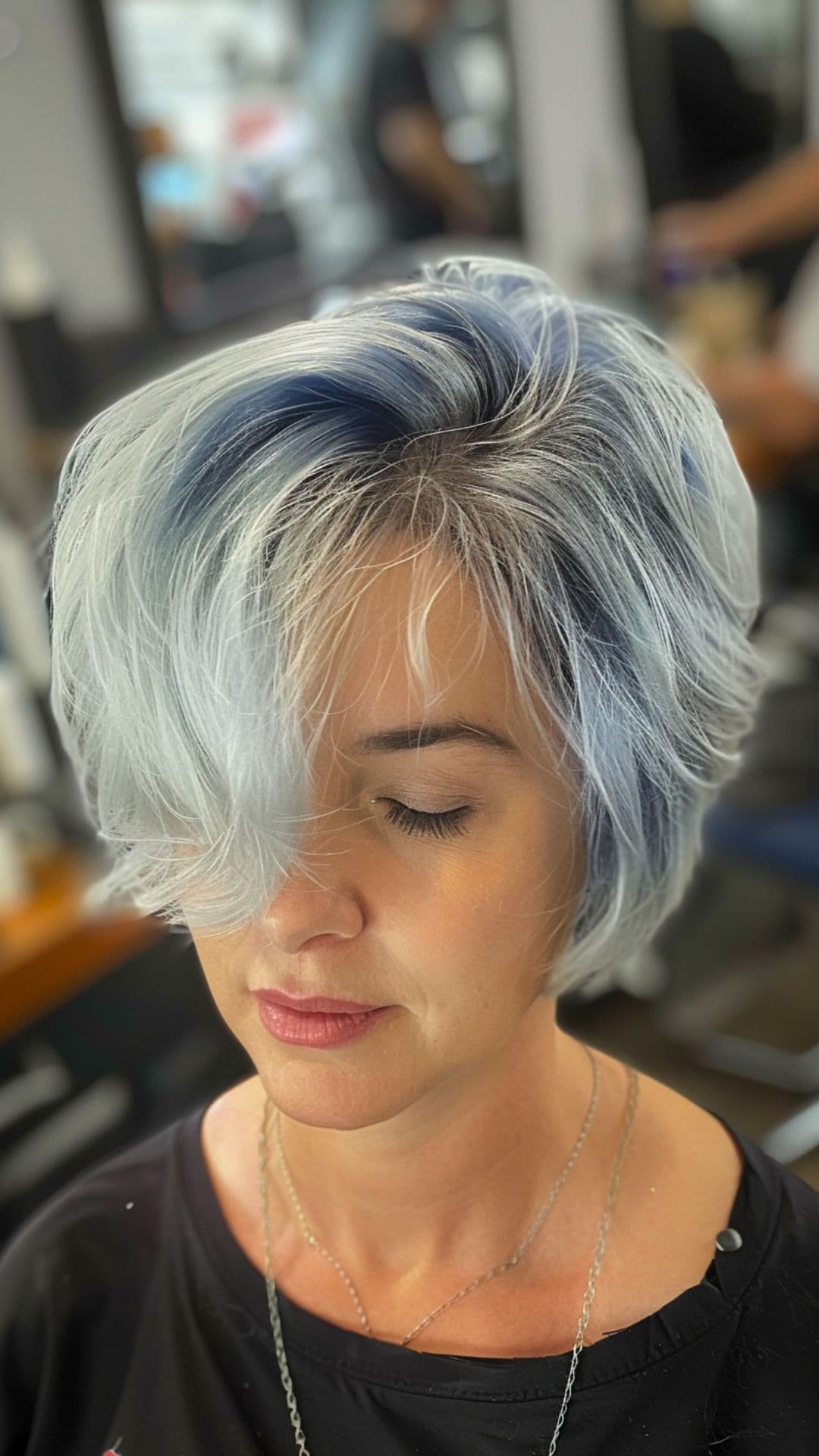 A woman modelling a short midnight denim silver hair.
