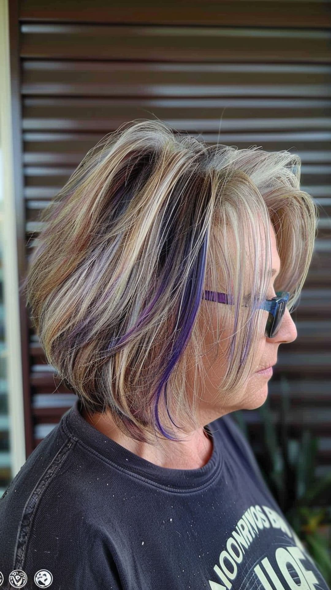An old woman modelling a razored bob with purple highlights.