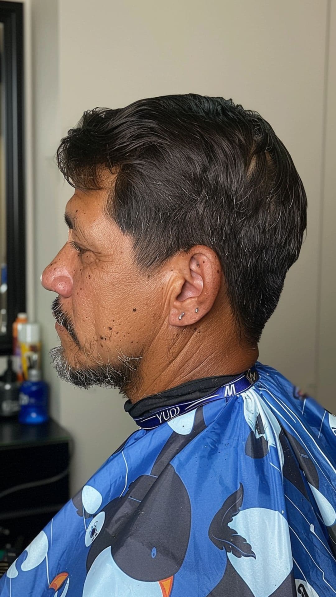 A middle aged man modelling a scissor haircut.
