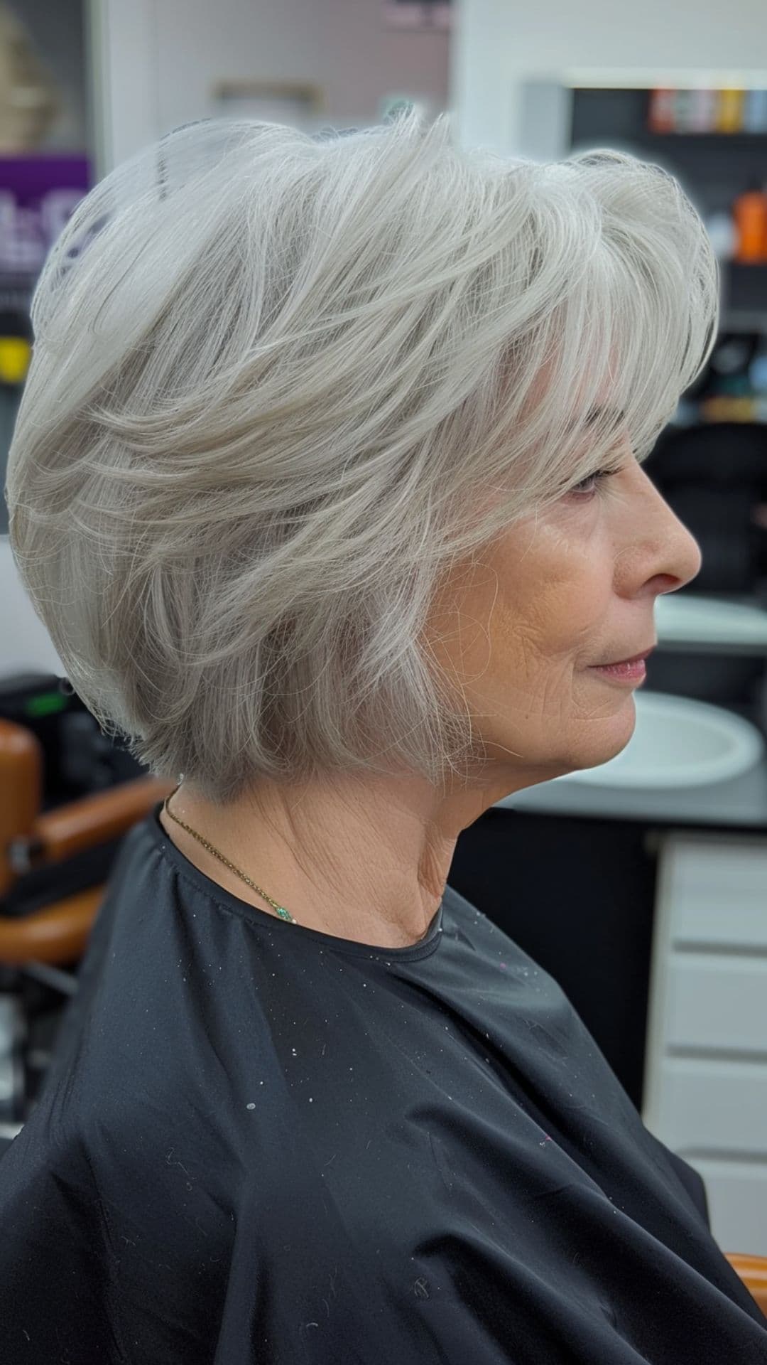 An old woman modelling a short layered cut with texture.