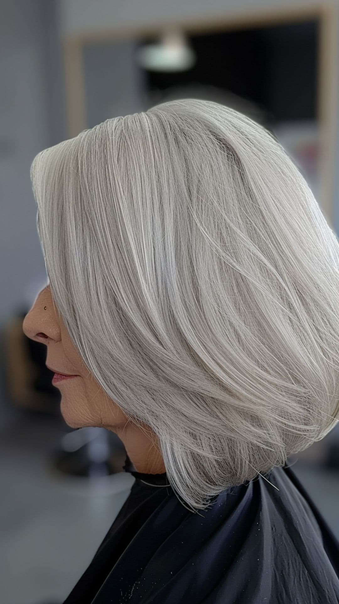 An old woman modelling a white blonde sleek bob.