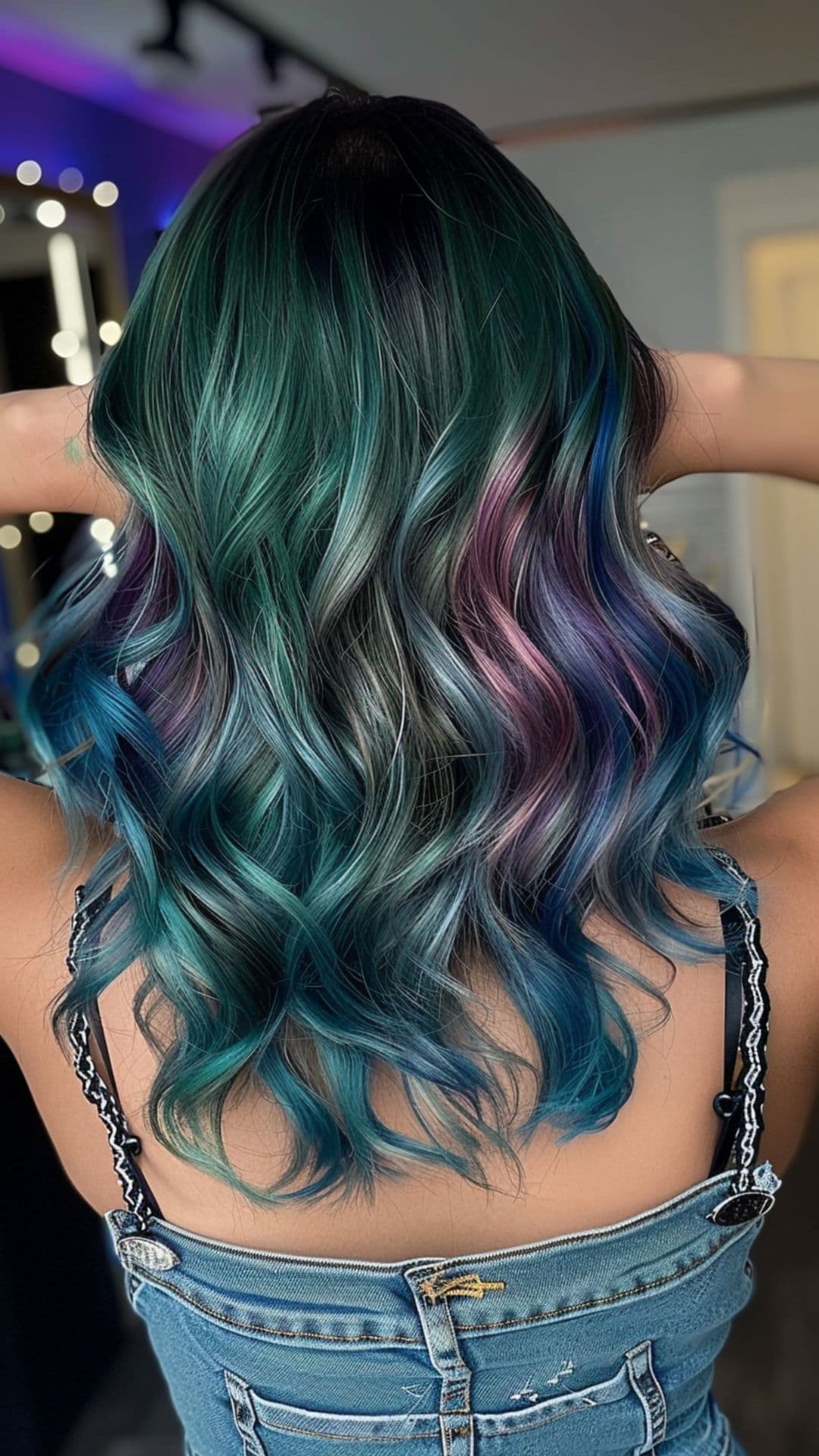 A woman modelling an aurora borealis insipred hair color.