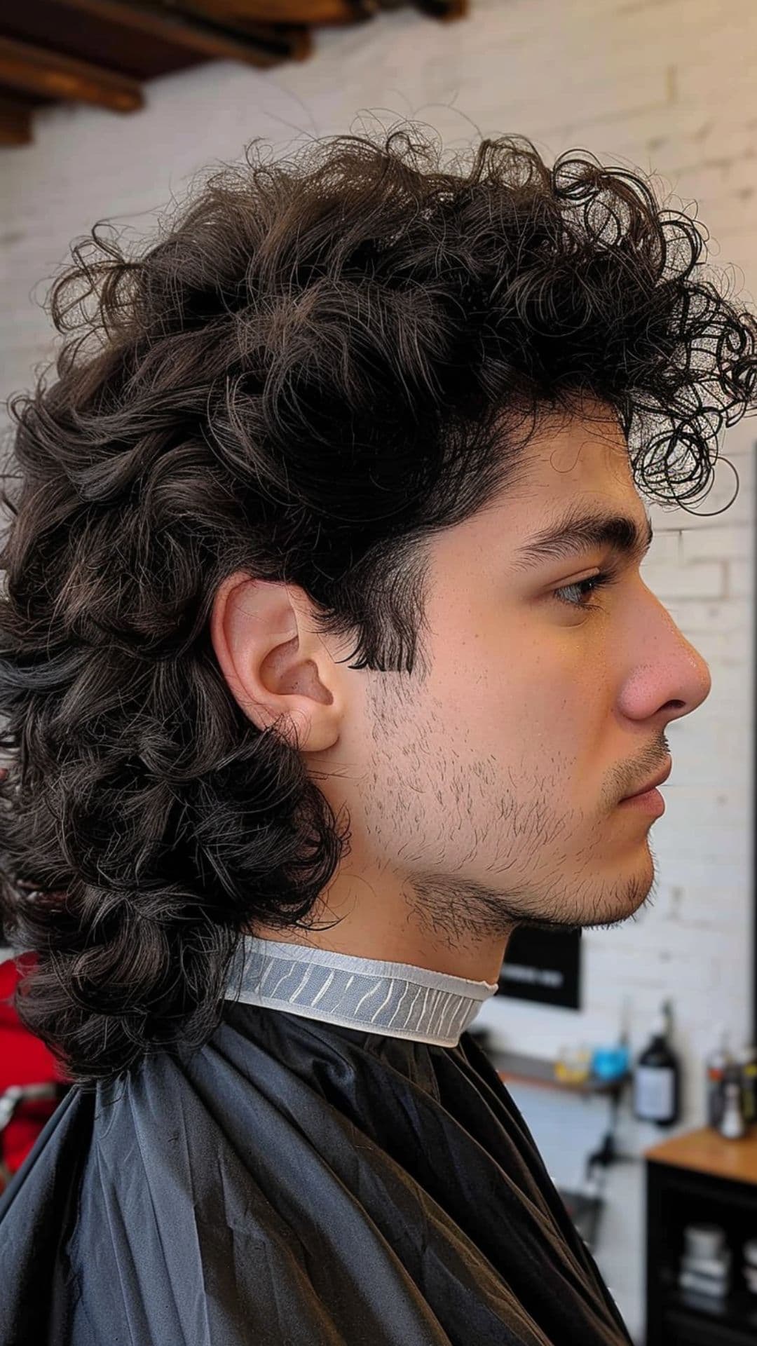 A man modelling a curly mullet hairstyle.