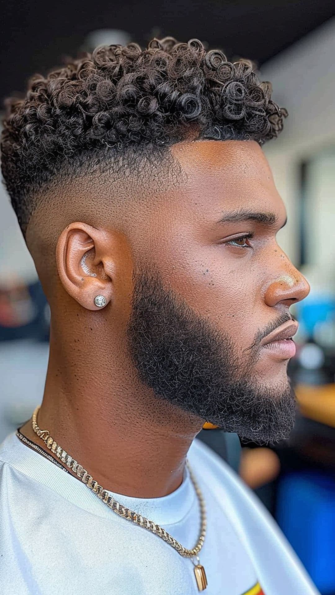 A black man modelling a curly top with fade haircut.