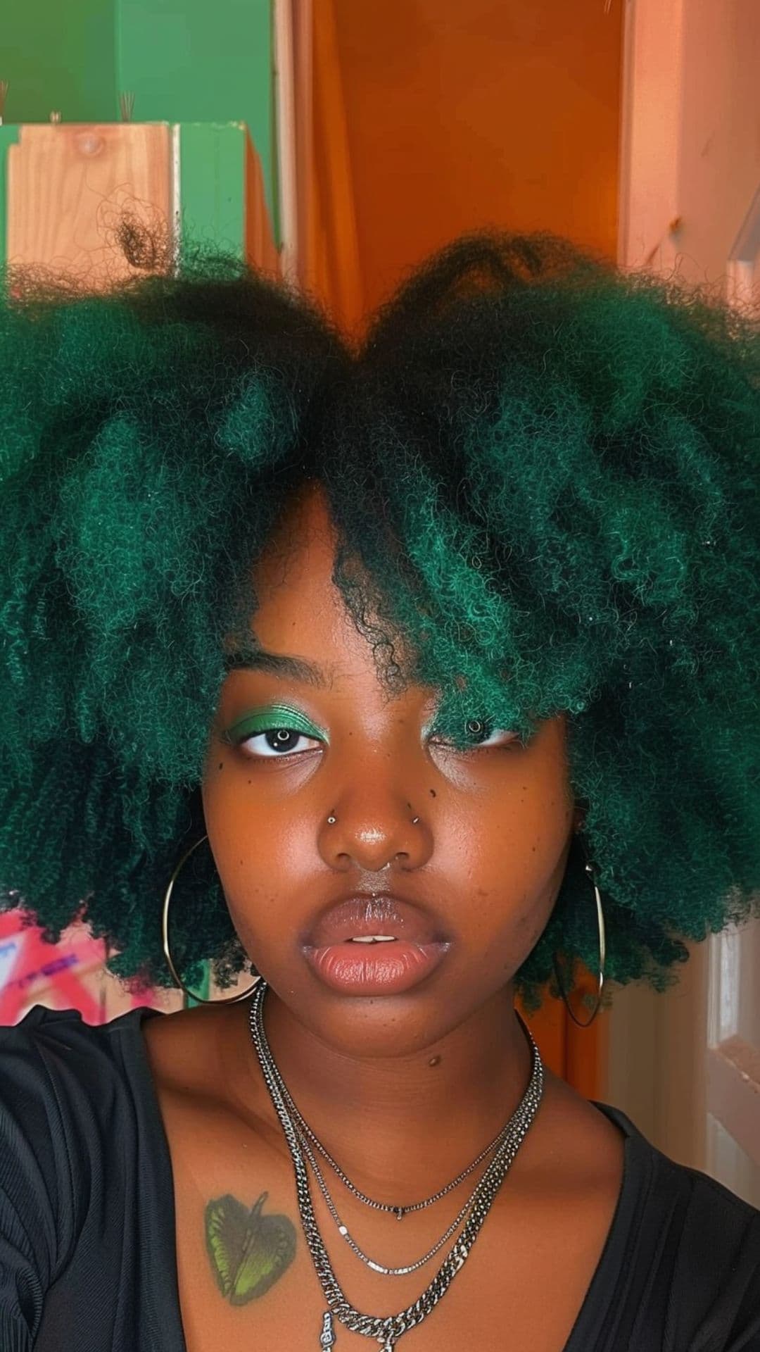 A black woman modelling an emerald green hair.