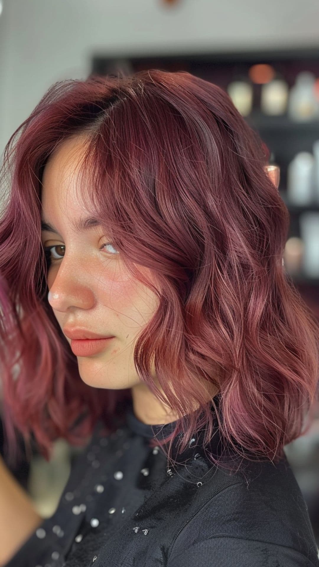 Uma mulher modelando um cabelo cor de vinho quente.