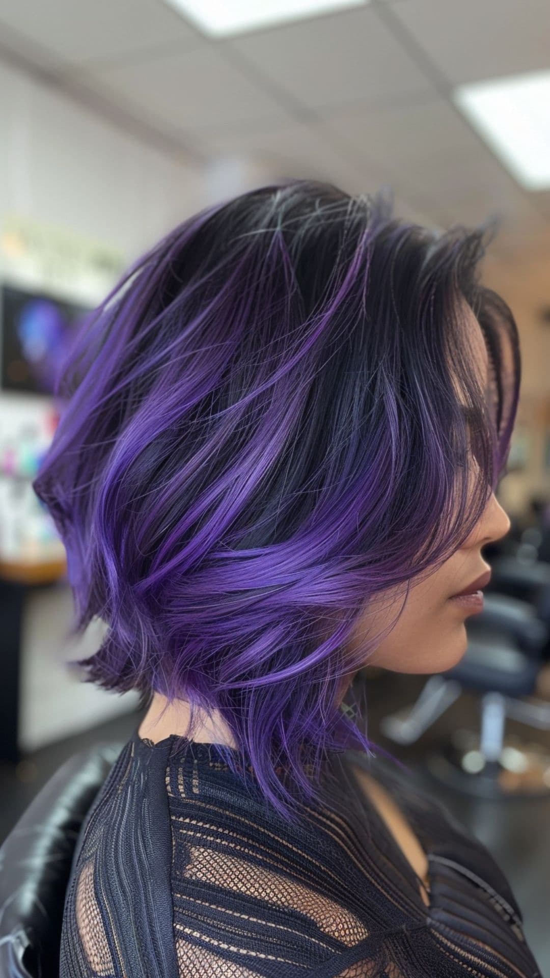 Uma mulher modelando um cabelo roxo com mechas grossas.