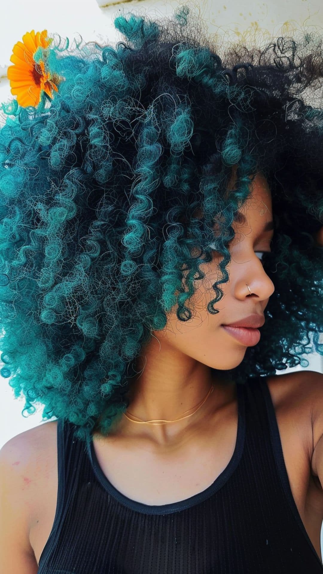 A black woman modelling a teal afro hair.