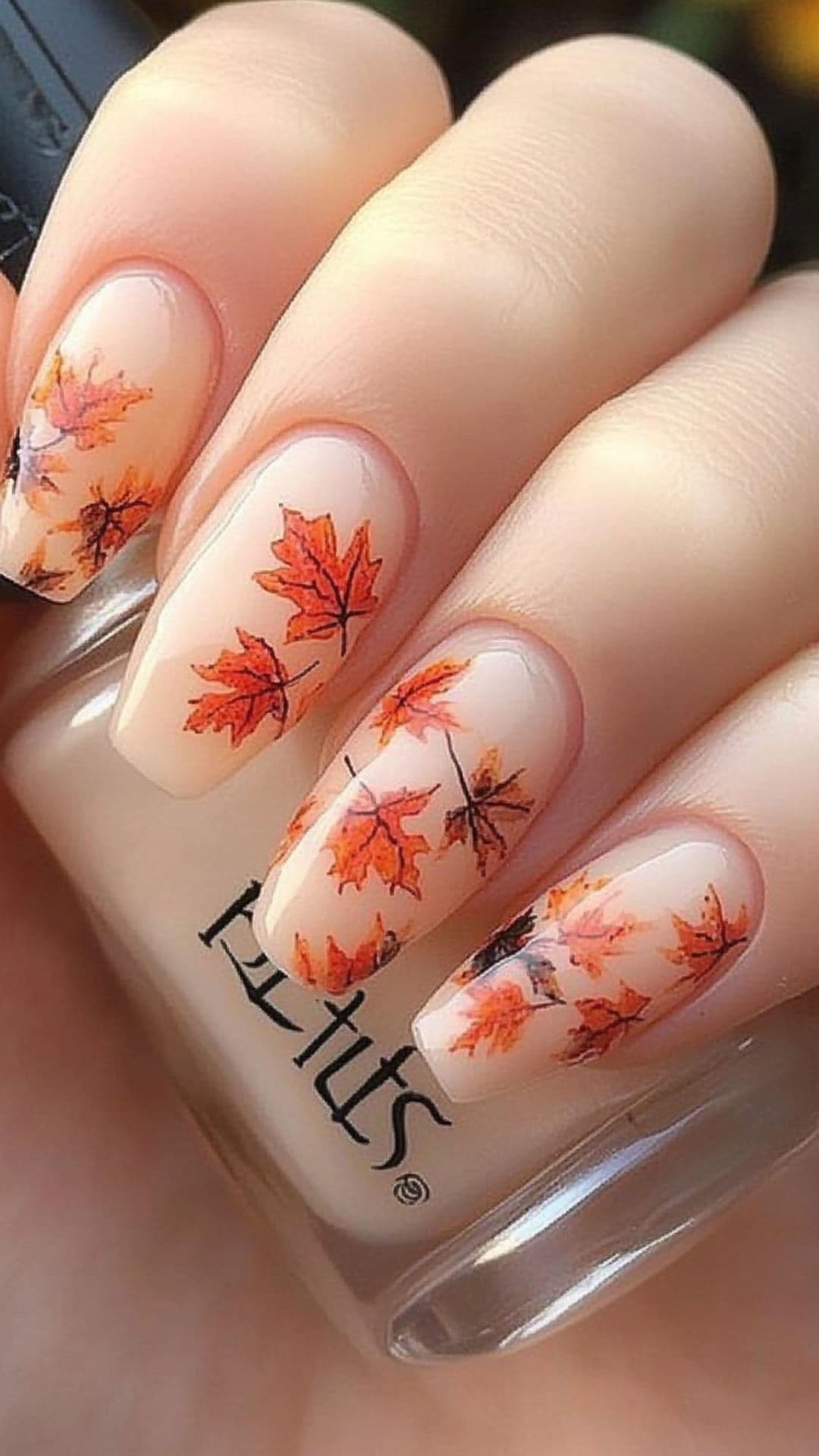 Woman's nails modelling Classic Fall Leaves on Nude Base design.