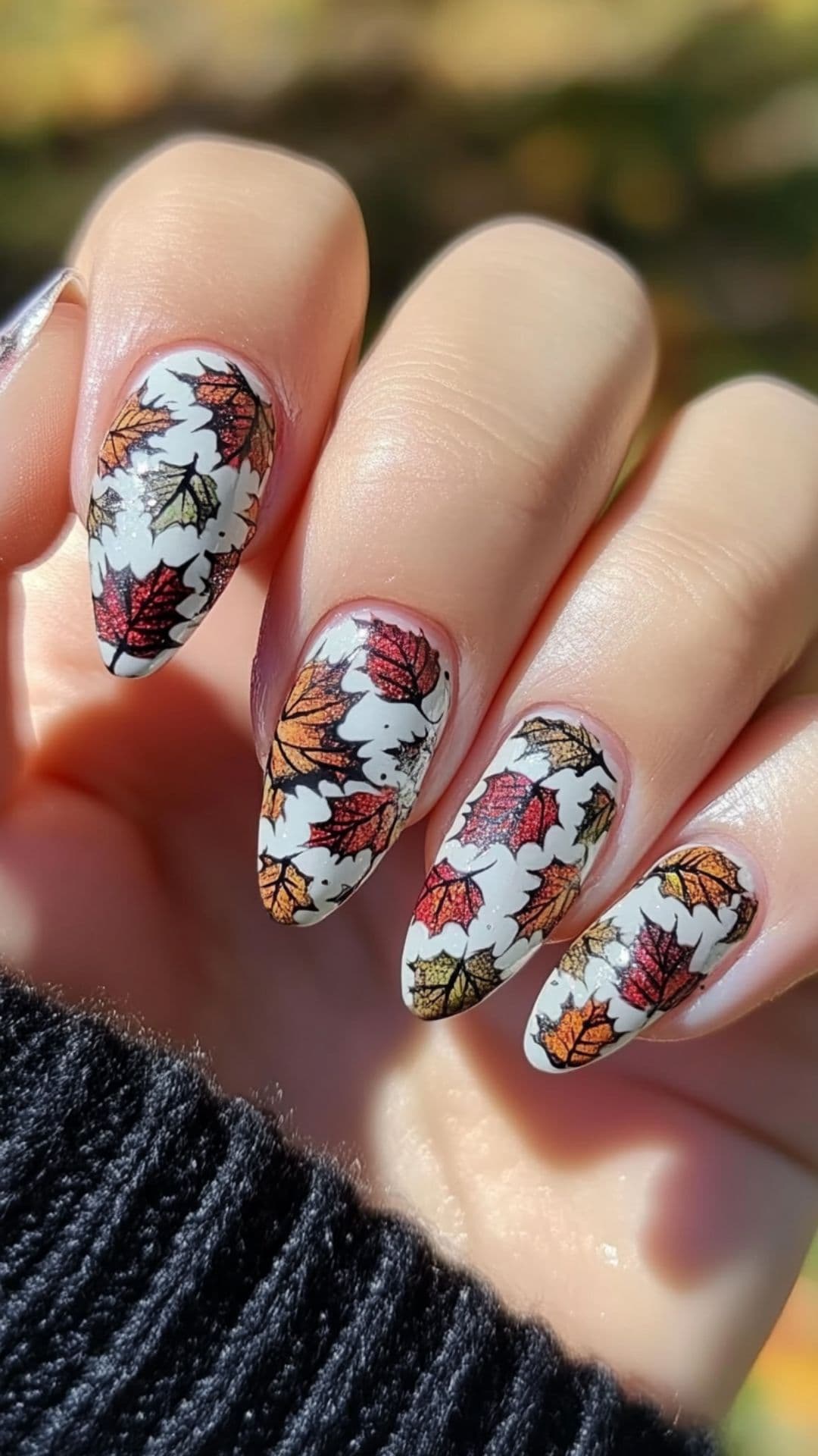 Woman's nails modelling Dark Rainbow Fall Leaves design.