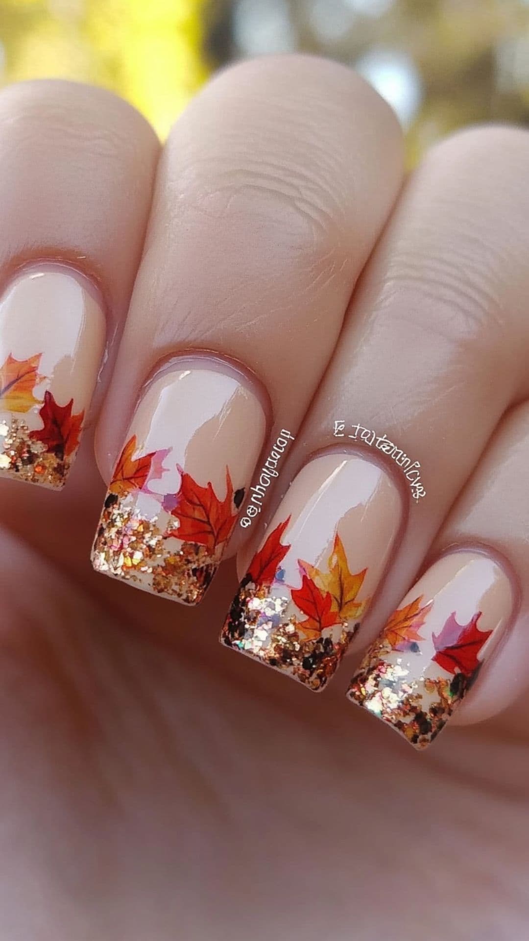 Woman's nails modelling French Tips with Leaf Designs.