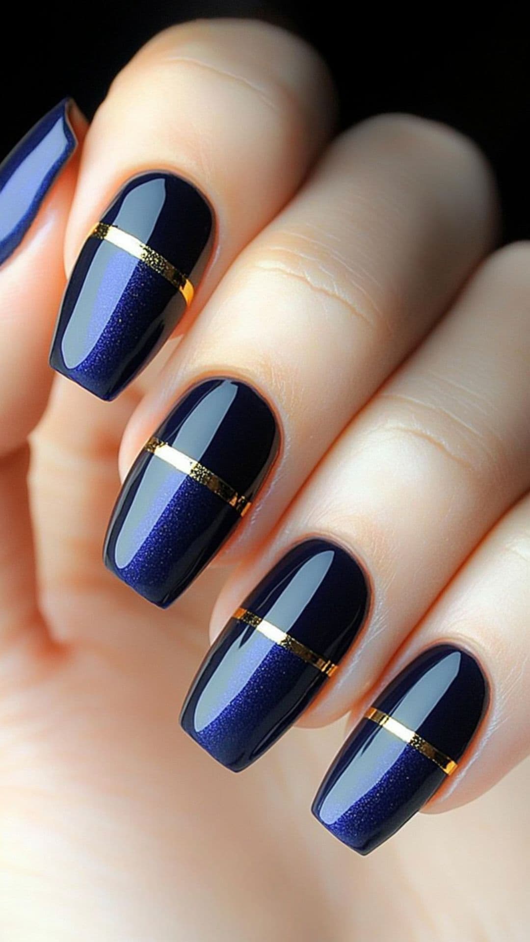 Woman's nails in Navy Blue with Thin Gold Stripes design.