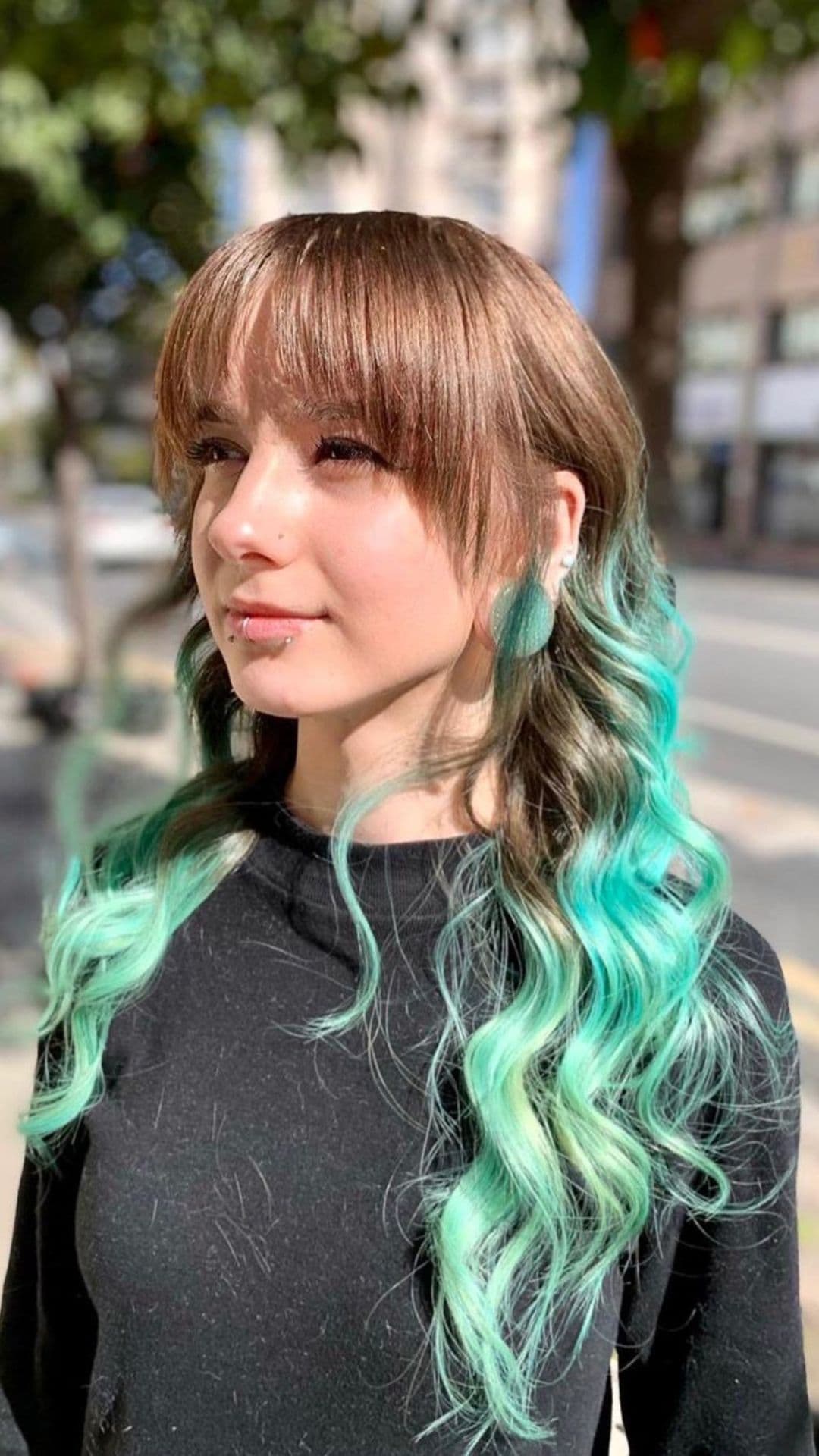 A woman modelling a Brown to Turquoise Ombre hairstyle.