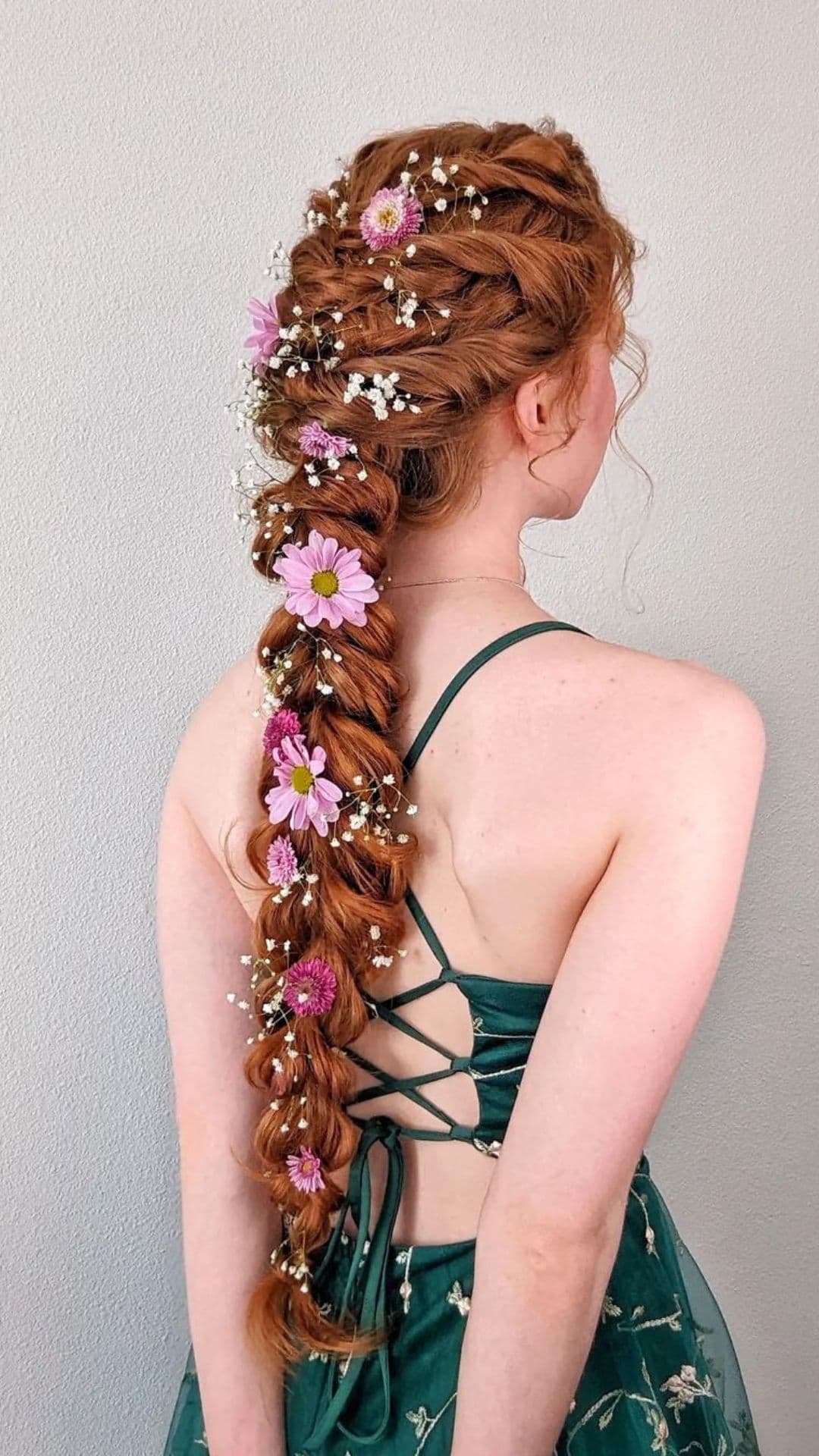 A woman modelling a Floral Braided Ponytail hairstyle.