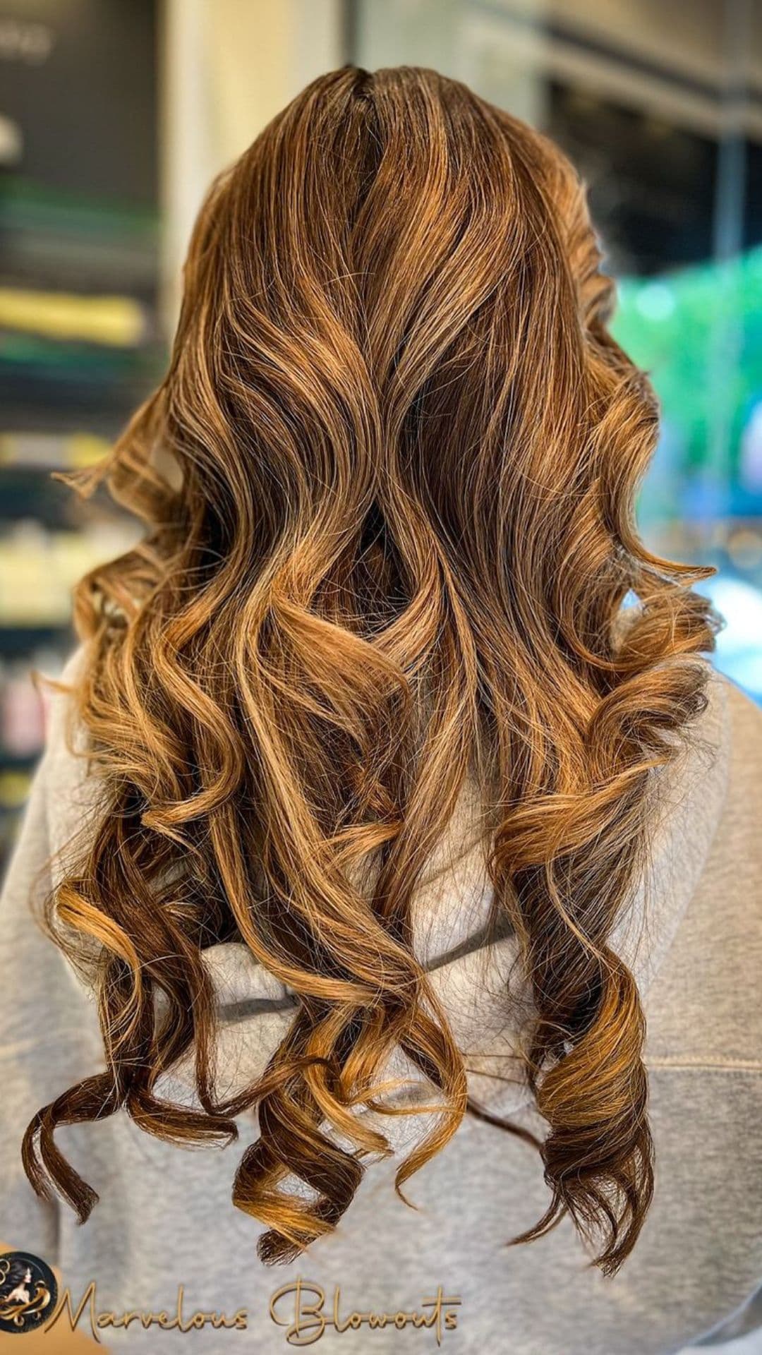 A woman modelling a Long Flowing Curls hairstyle.