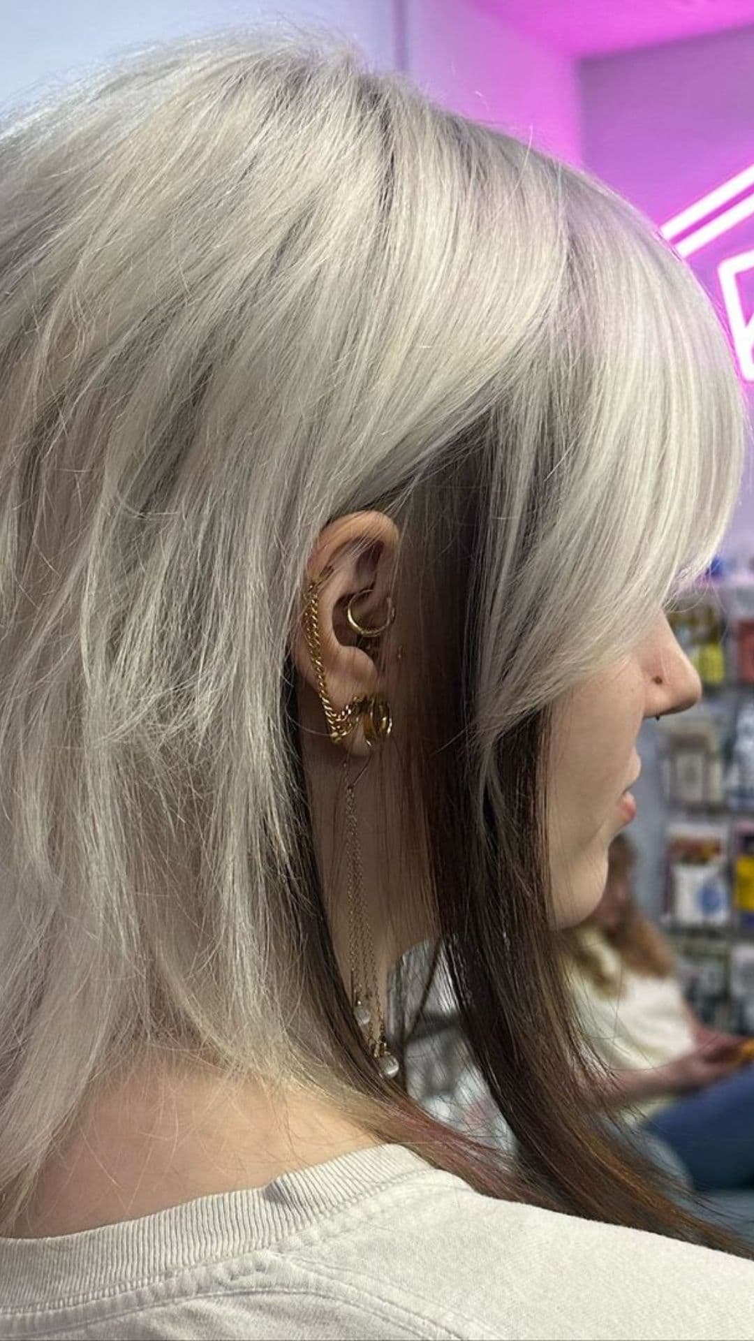 A woman modelling a White Blonde Elf Cut with Brown Peek-a-boo hairstyle.