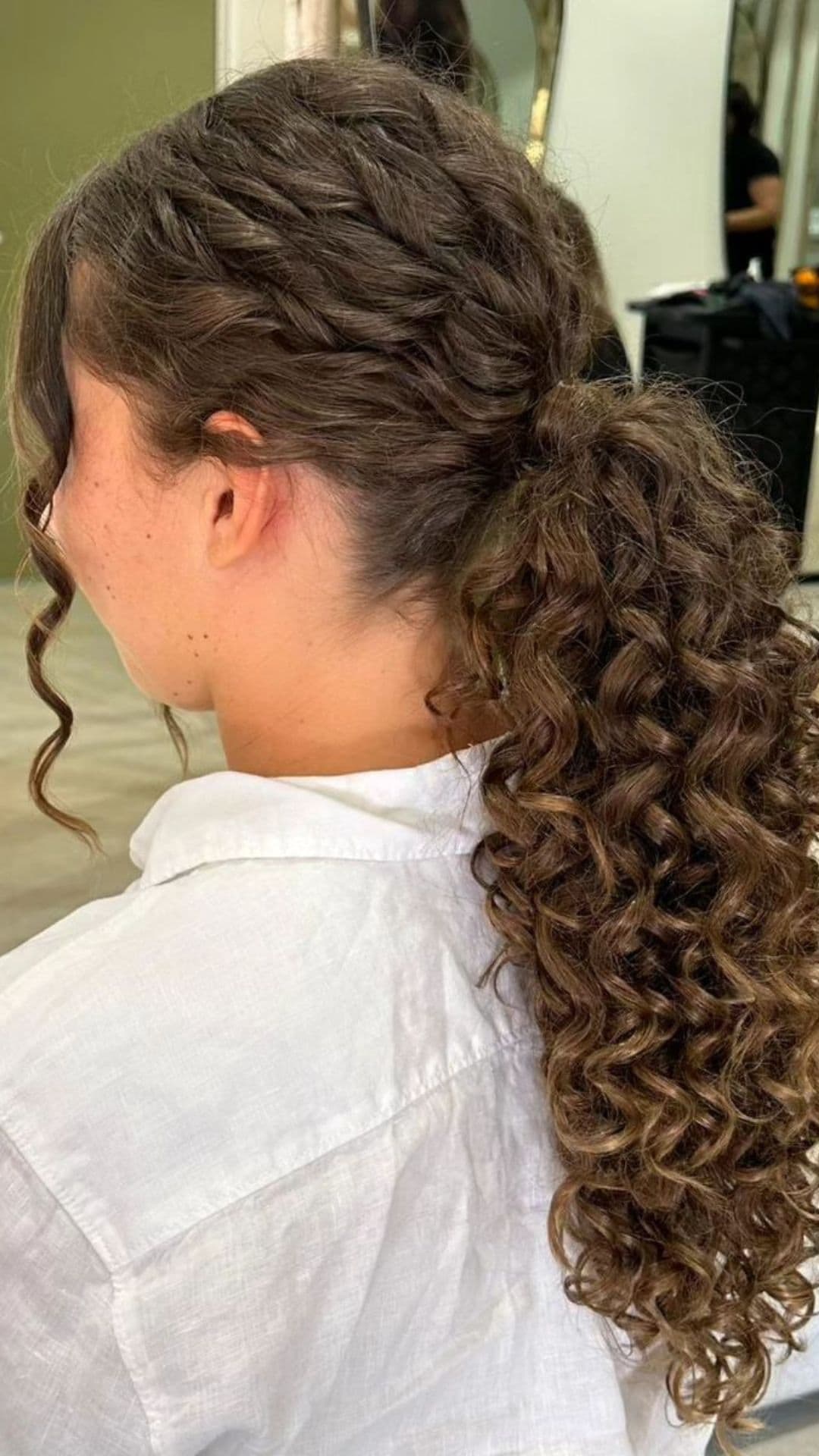 A person models a Curled Ponytail hairstyle.