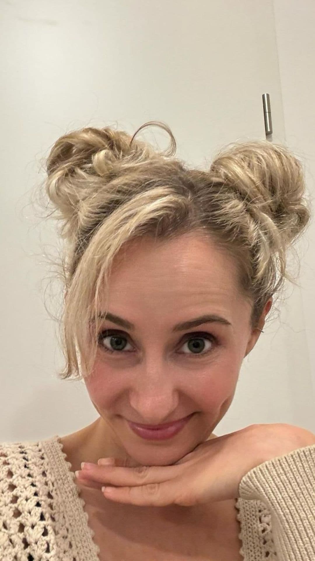 Woman smiling and modeling a Double Buns hairstyle.