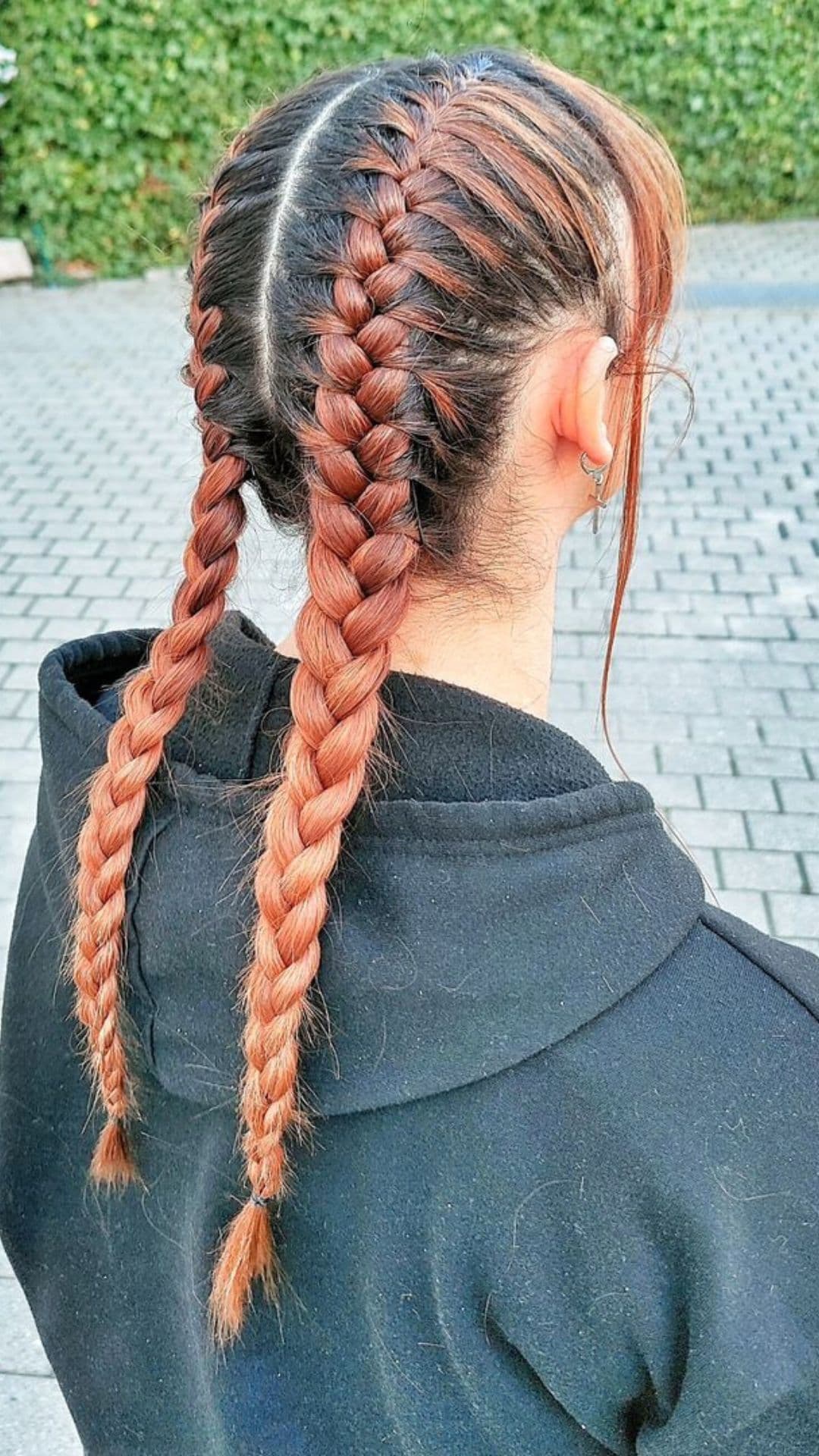 Person wearing a black hoodie shows off Double French Braids hairstyle, facing away from the camera.