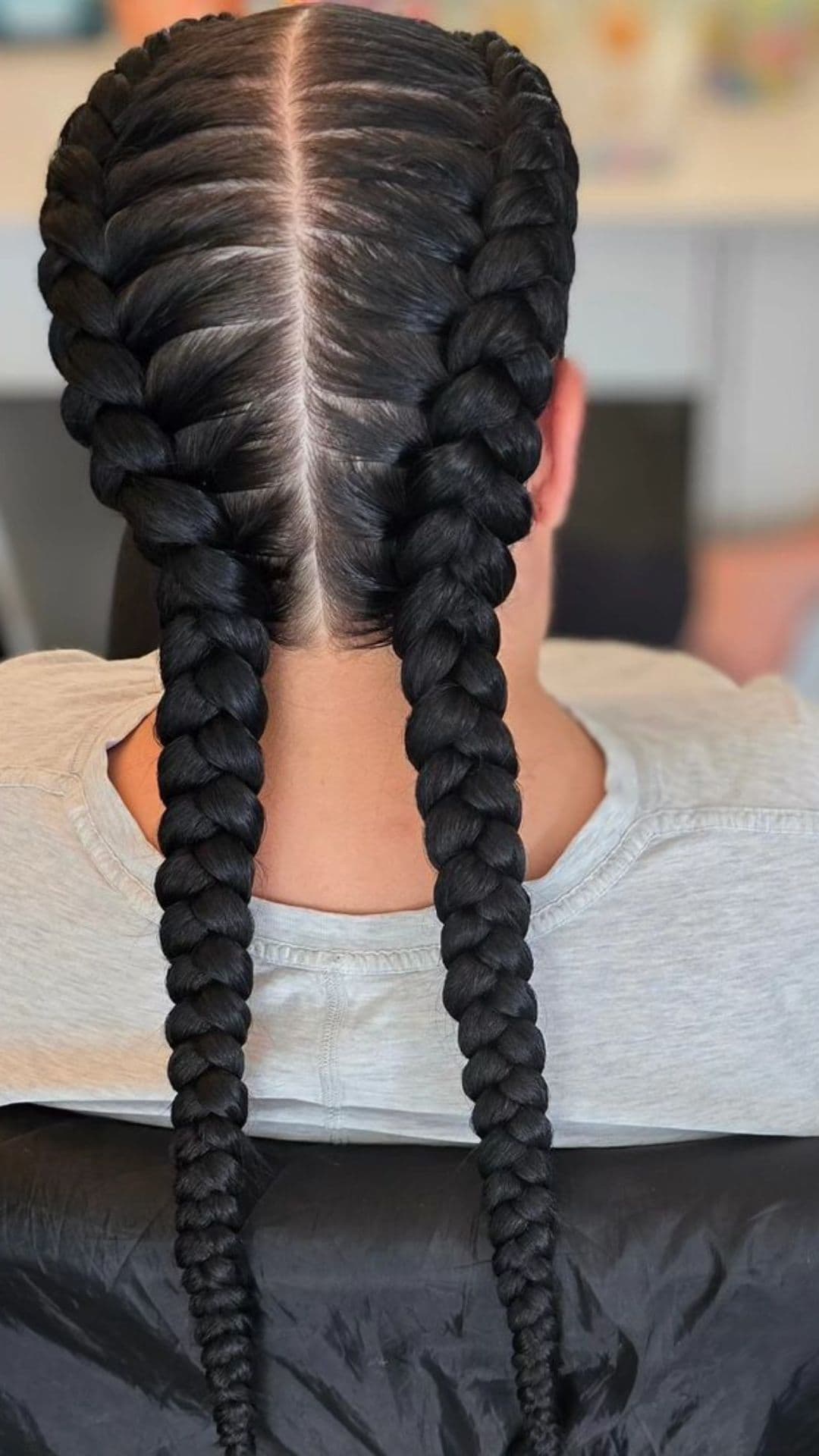 Close-up of a person with Dutch braids. The hair is neatly styled in two thick braids down the back.