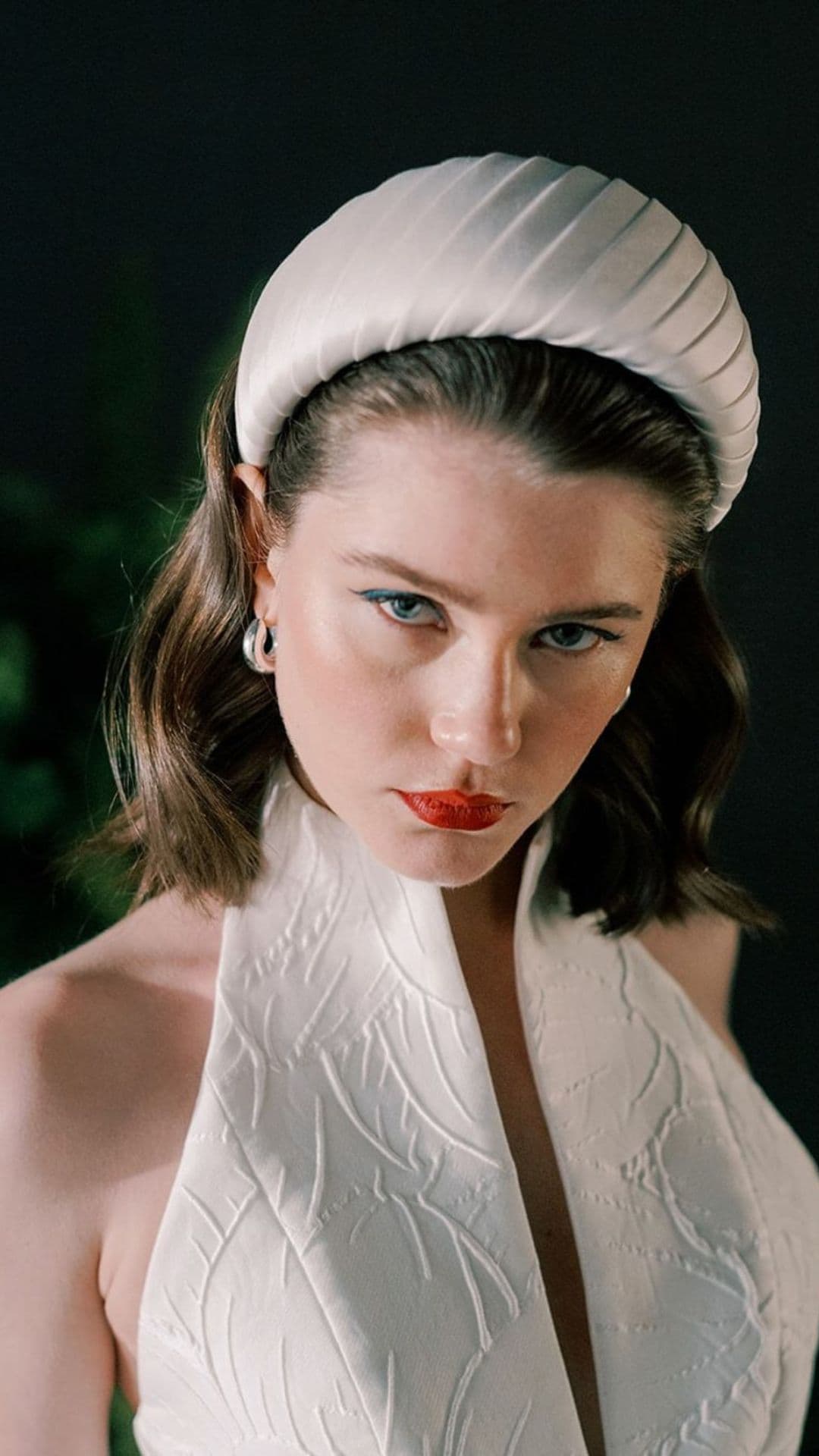 Model wearing a white XXL headband hairstyle with a white textured top.