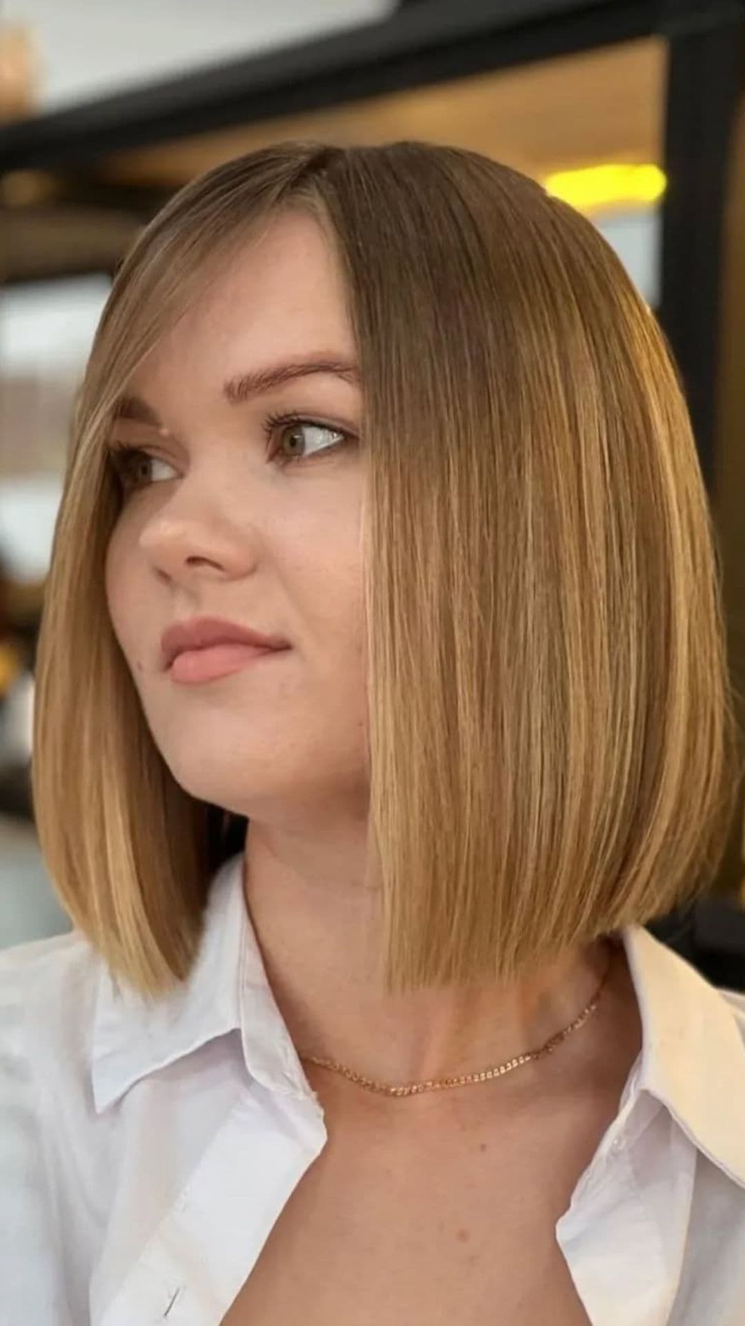 A woman with a round face modelling a Bob with Deep Side Part hairstyle.