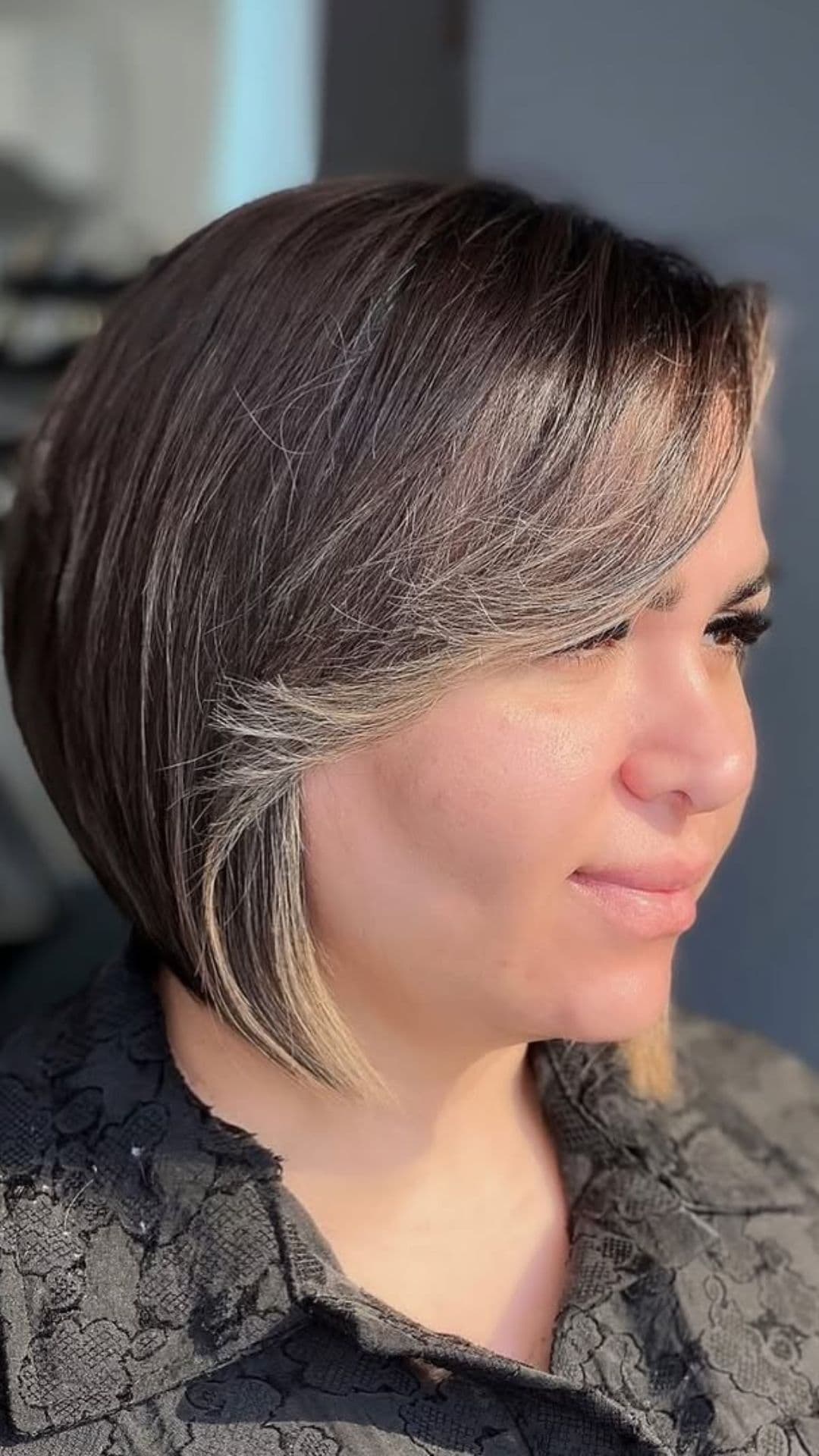 A woman with a round face modelling a Bob with Highlights hairstyle.