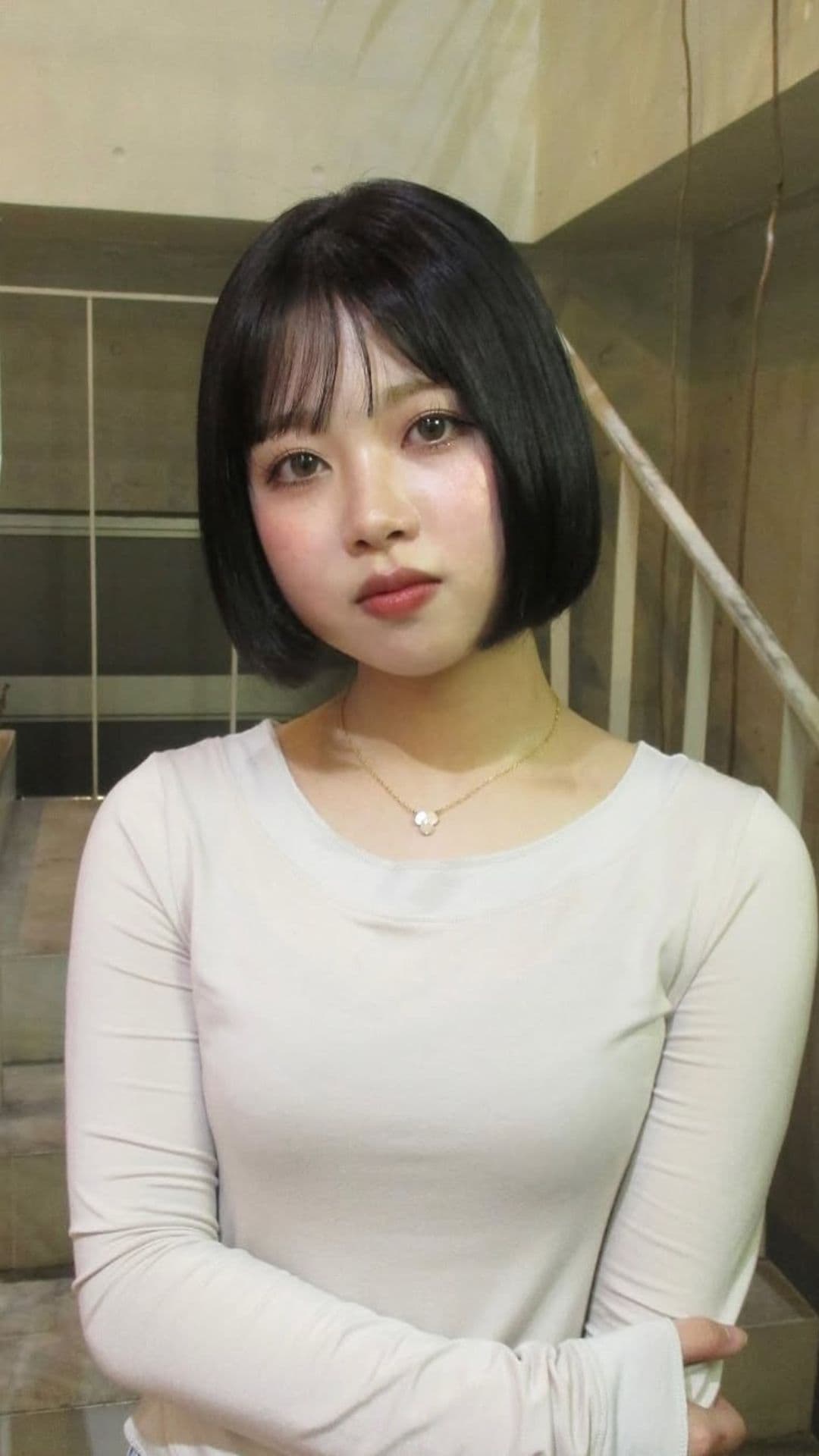 A woman with a round face modelling a Bob with Side-Swept Fringe hairstyle.