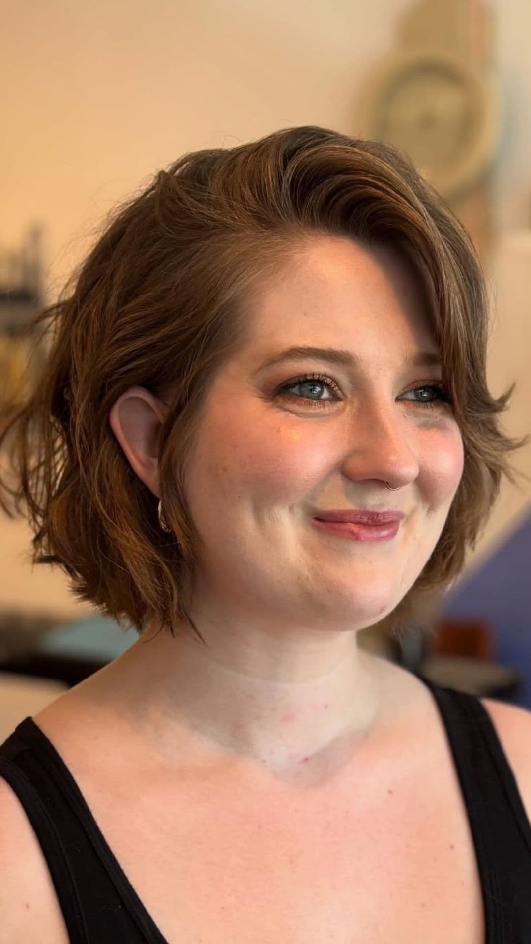 A woman with a round face modelling a Chin-Length Bob with Wispy Ends hairstyle.