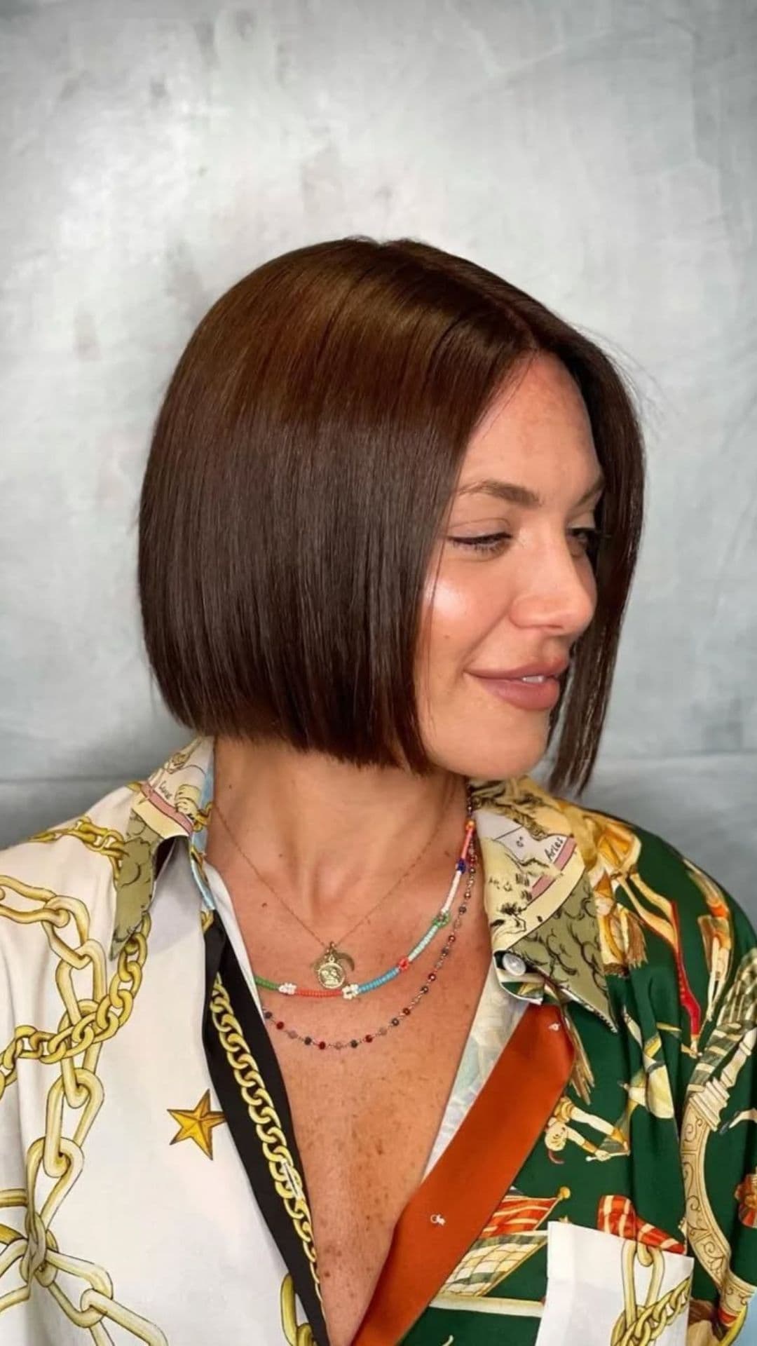 A woman with a round face modelling a Classic Chin-Length Bob hairstyle.