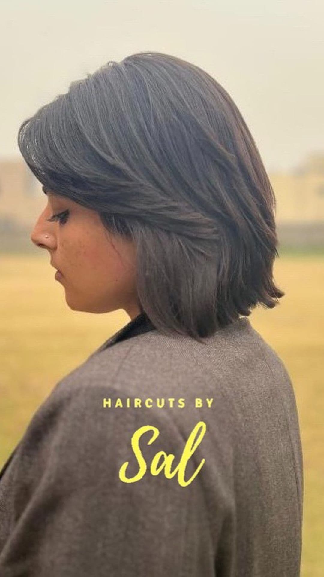 A woman with a round face modelling a Layered Bob with Feathered Bangs hairstyle.