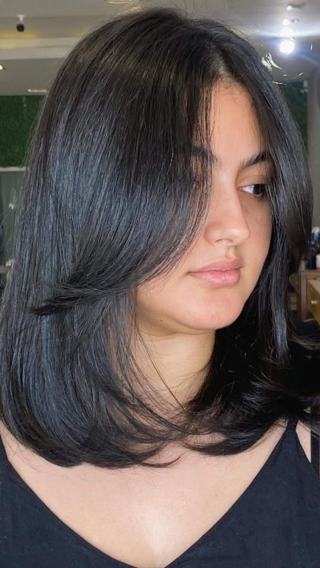 A round-faced woman with double chin modelling a Long Bob hairstyle.