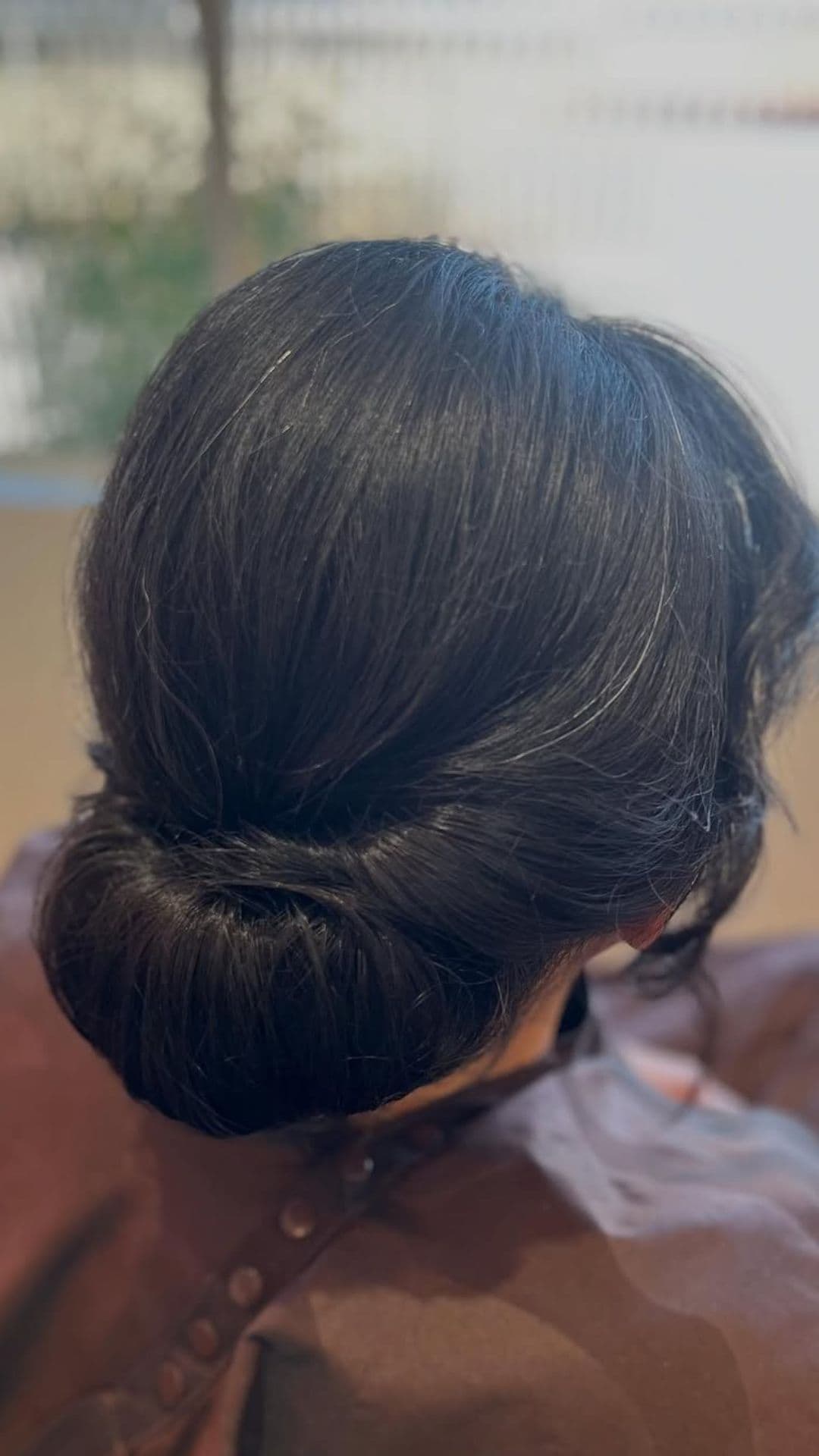 An old woman modelling a Low Twisted Bun hairstyle.